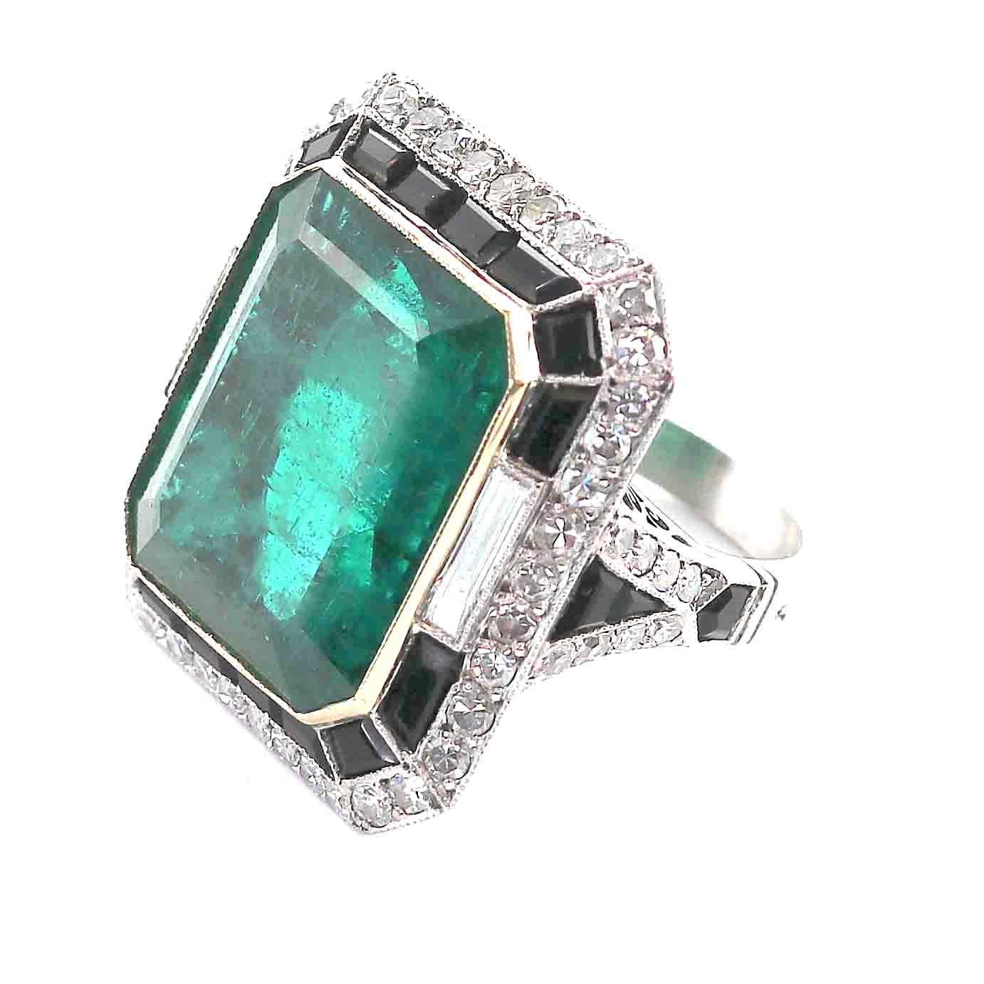 An emerald ring goes with everything. An elegantly bold homage to Art Deco style, highlighted with a 23.53 carat Zambian emerald that glows on the hand and instills a sense of personal power. With perfectly cut jet black onyx, and beautifully framed