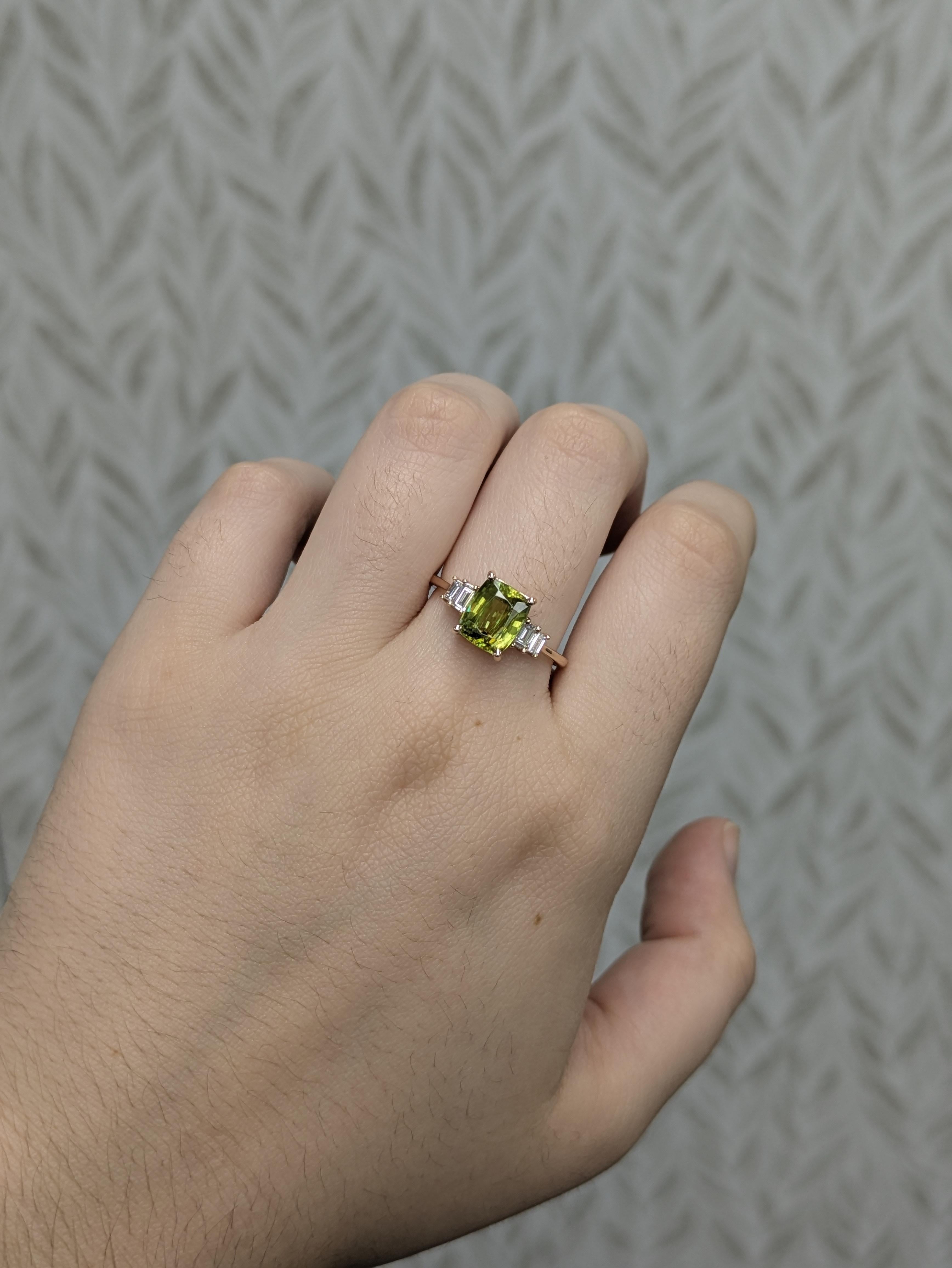 Con una vibrante esfena talla esmeralda de 8x6 mm (2,36 ct) sin tratar, este anillo deslumbra por su ardiente brillo y su rara dispersión. Engastada en oro de 14k (2,18 g) y acentuada con 4 diamantes (0,20 ctw), es una pieza audaz y luminosa que