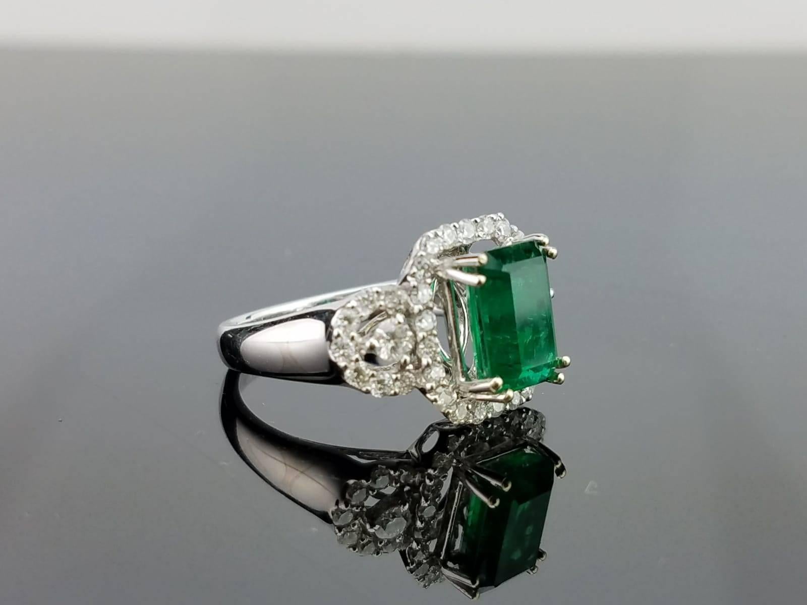 Ein klassischer und eleganter Ring mit einem 2,36 Karat schweren sambischen Smaragd von hoher Qualität und Reinheit in der Mitte und Diamanten, die auf einem 18-karätigen Goldband gefasst sind. 

Details zum Stein: 
Stein: Smaragd
Karatgewicht: 2,36