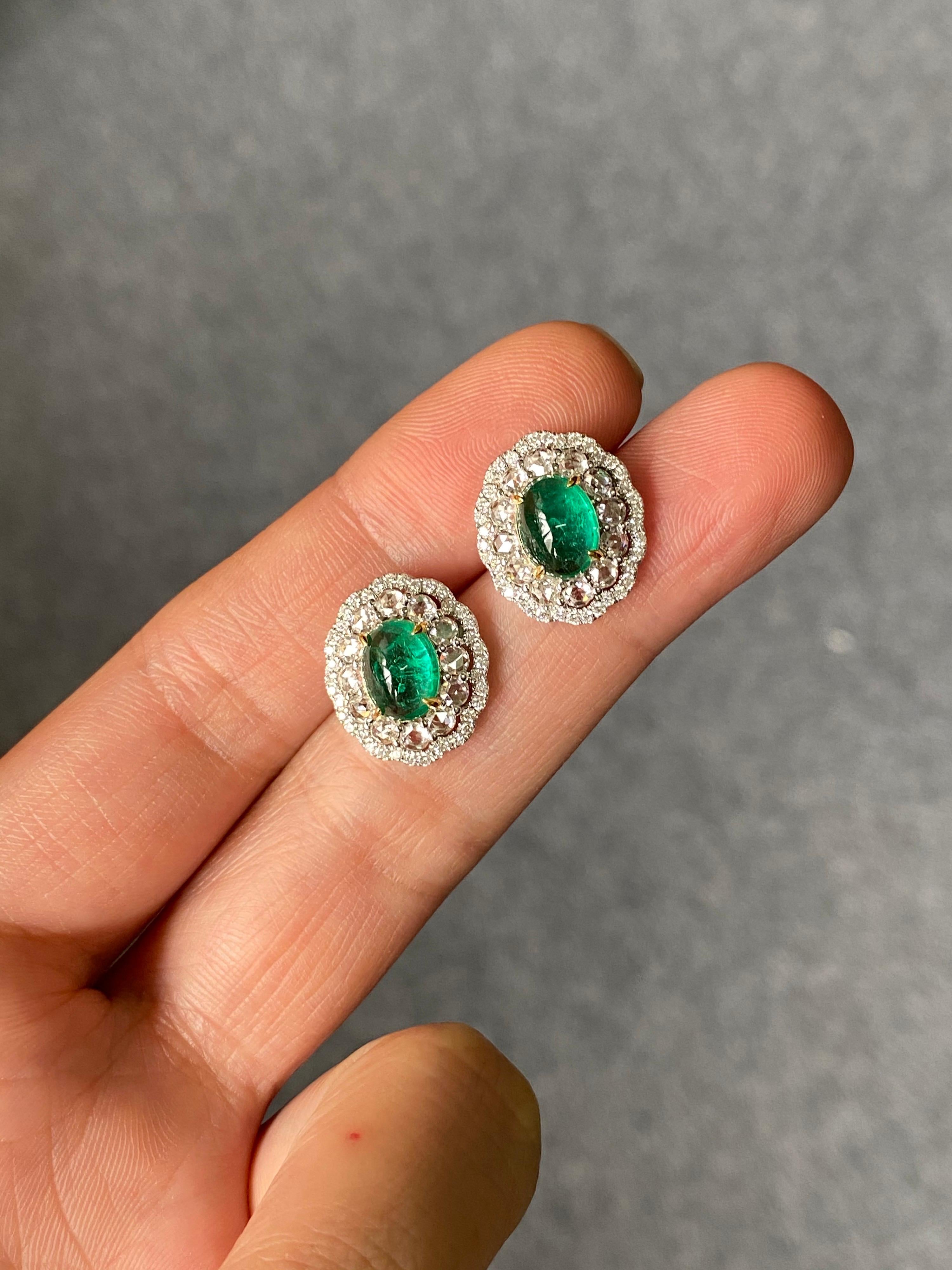 A very elegant pair of 2.36 carats Zambian Emerald cabochons, surrounded with 1.31 carats of VS quality, colorless rose-cut Diamonds and brilliant cut diamonds, all set in 4.4 grams of solid 18K White Gold. The earrings come with a push-pull