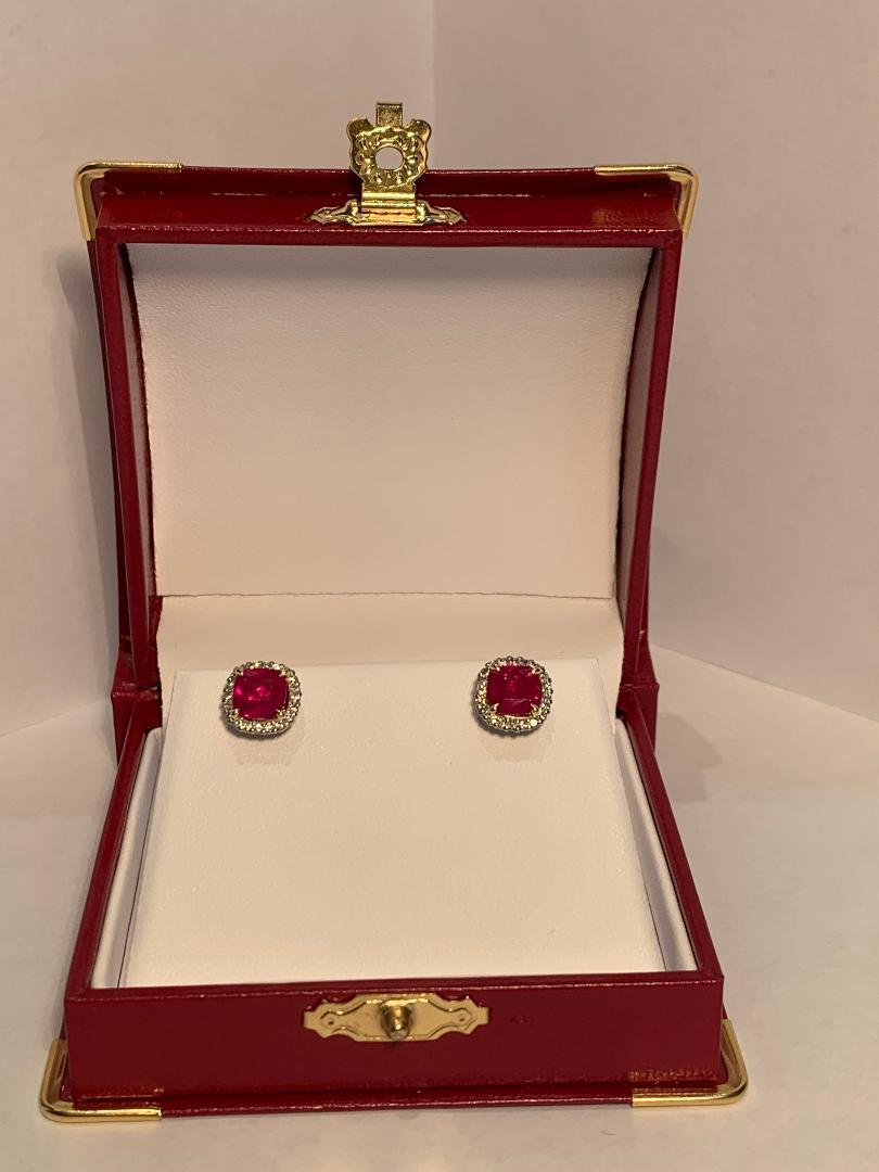 Very elegant and striking, platinum post pierced earrings feature 18 karat yellow gold talon prong set squarish round shaped cushion cut vivid red rubies. Rubies are set in 18 karat yellow gold baskets which are set inside a platinum basket. The
