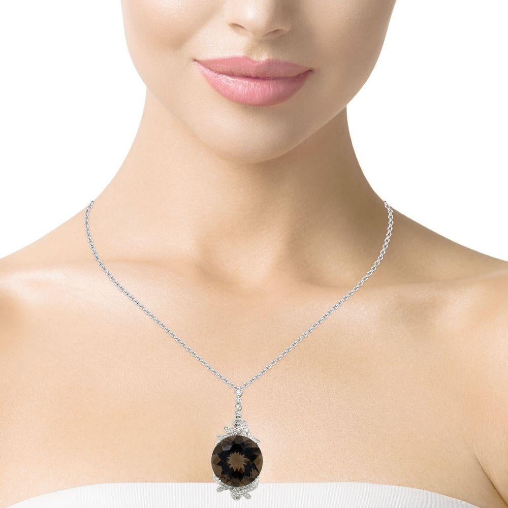 This stunning pendant has a top quality 20x20mm round checkerboard Smokey Topaz with a double 4 prong setting in 14 karat white gold. There are 64 shimmering brilliant cut diamonds all round the stone for a delicate accent. This pendant comes in a