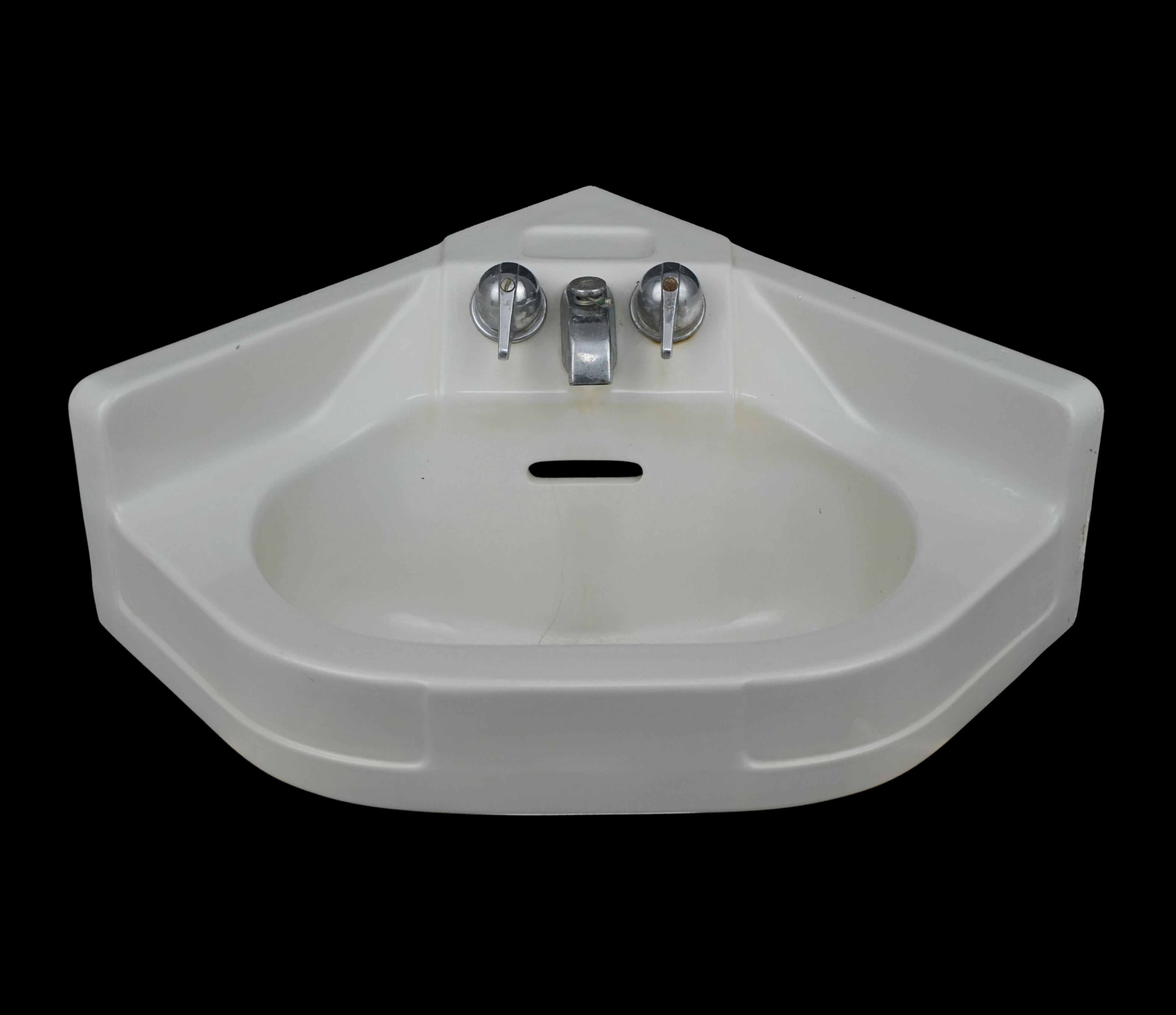 Crane Cornate corner wall sink made of ceramic with a white porcelain finish. The original nickel hardware was also made by Crane. Good condition with normal wear and tear. Unknown working condition on the faucets. One available. Please note, this