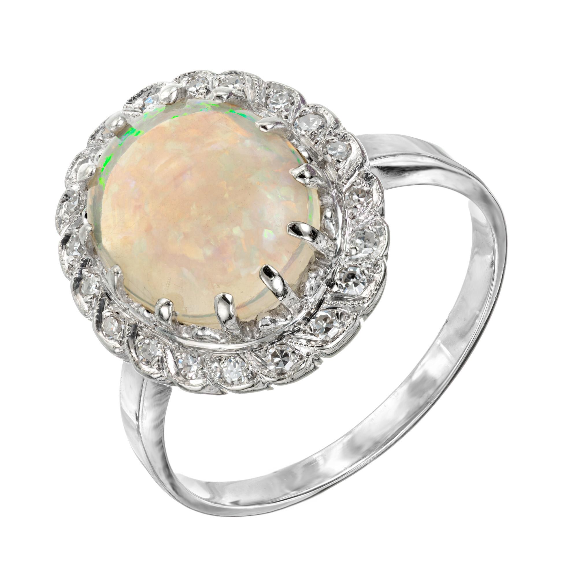 1950's Opal and diamond ring. Oval red, blue orange flash opal in a 14k white gold setting with a halo of 21 round cut diamonds. 

1 oval white crystal with red, orange, yellow and blue flash Opal, approx. total weight 2.37cts, 12.4 x 10.4mm
21