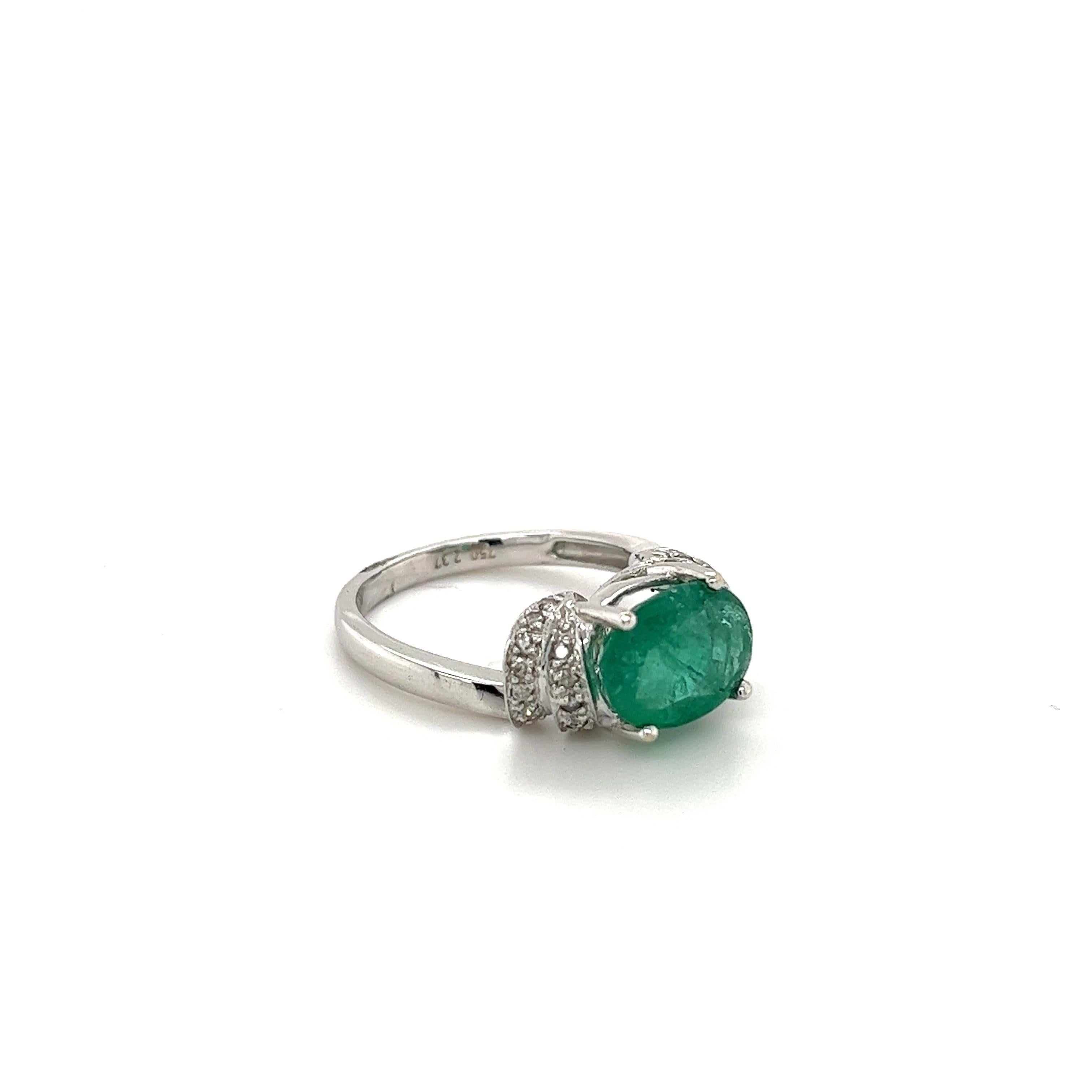 Lively Colombian Emerald ring mounted in 14k solid white gold. Oval cut natural emerald is prong set and adorned with 0.24 carats in colorless natural diamonds. This Emerald has a deep light green color hue, with excellent luster and translucence.