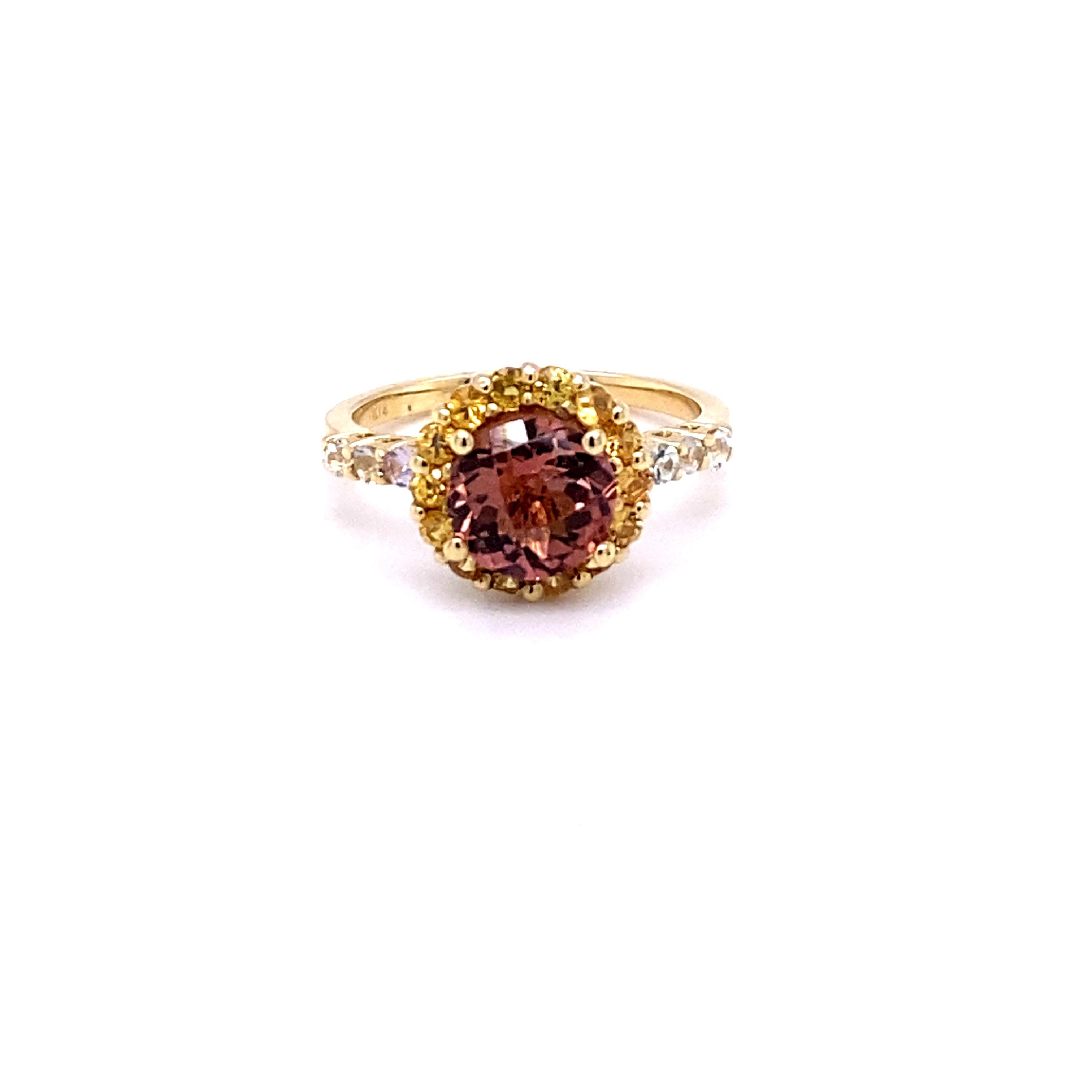 This ring has a 1.53 carat Round-Checkered Cut Tourmaline that is set in the center of the ring and is surrounded by 14 Yellow Sapphires that weigh 0.55 carats and 6 White Sapphires along the shank of the ring that weighs 0.29 carats . The total