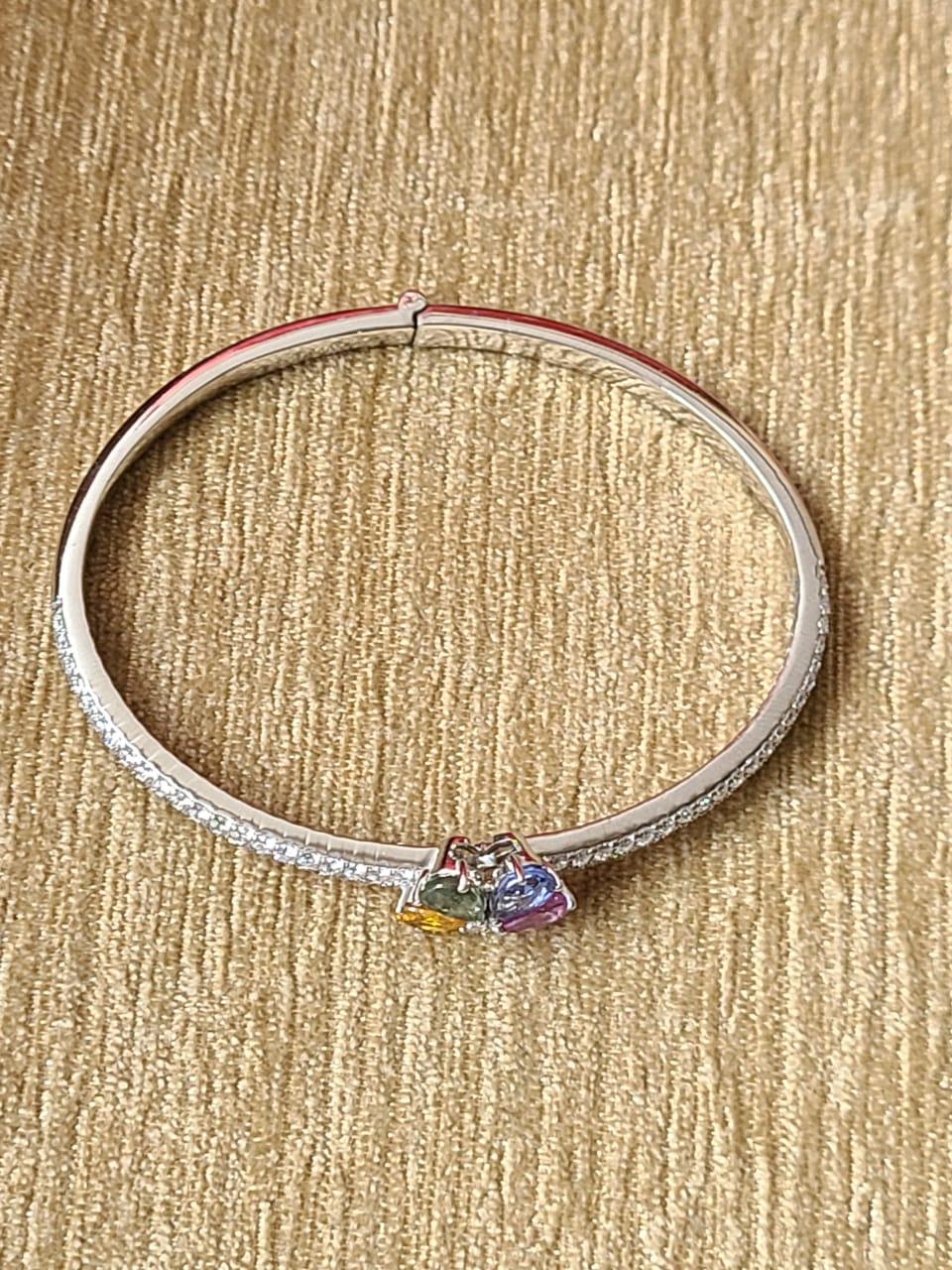 A very chic Multi Sapphire Modern/ Bangle Bracelet set in 18K White Gold & Diamonds. The weight of the Multi Sapphires is 2.37 carats. The Multi Sapphires are of Ceylon origin. The combined weight of the Diamonds is 1.57 carats. Net Gold weight is