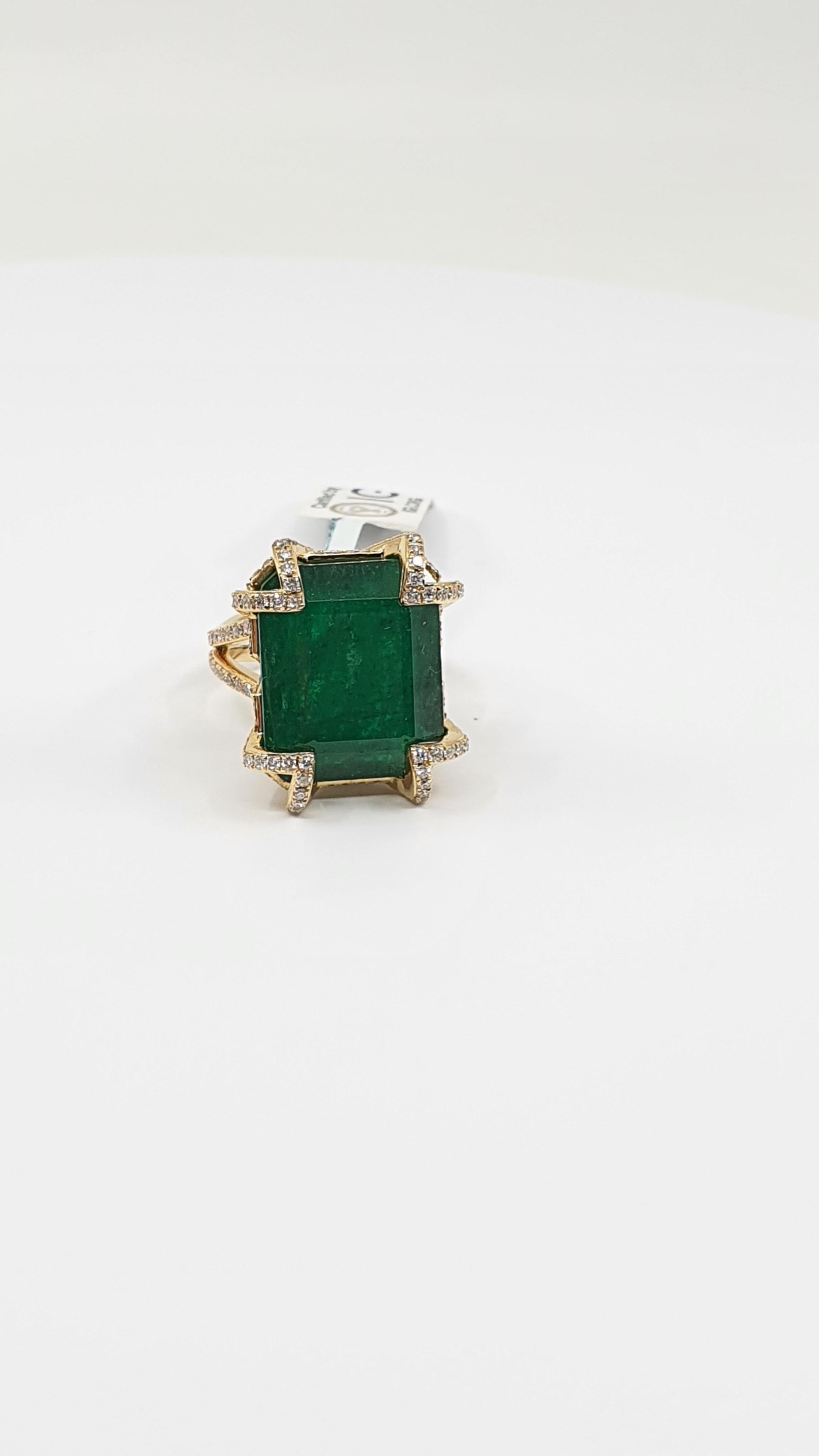 This stunning 22.29 Ct dark green square cut Emerald is a real treasure among gemstones. This precious stone is encrusted in 18 K yellow gold double ring with 210 inlaid round cut diamonds. The giant emerald is beautifully hugged with golden corners
