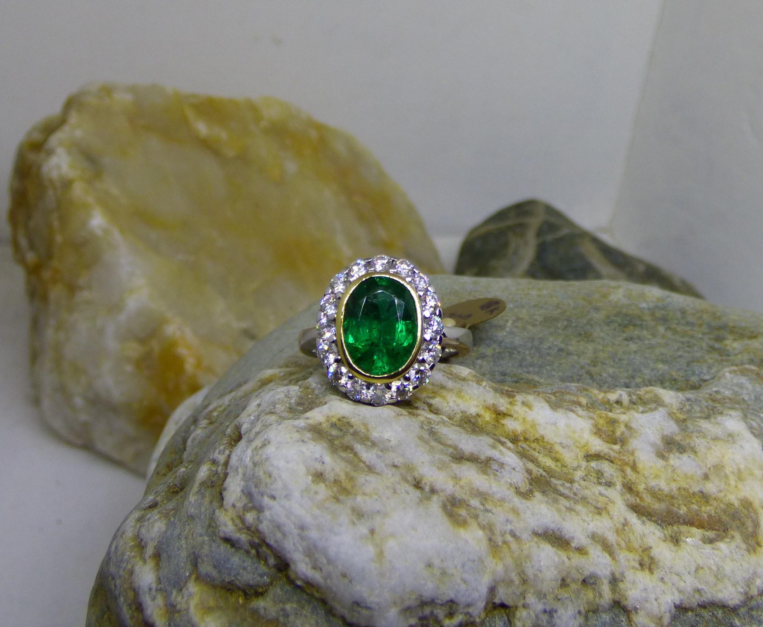 Ein leuchtender und farbenfroher ovaler Smaragd von 2,37 Karat ist der Mittelpunkt dieses Rings. Der 10 x 8 mm große Smaragd ist von 16 Diamanten mit einem Gesamtgewicht von 0,86 ct umgeben.  Die Gesamtgröße der Vorderseite des Rings beträgt