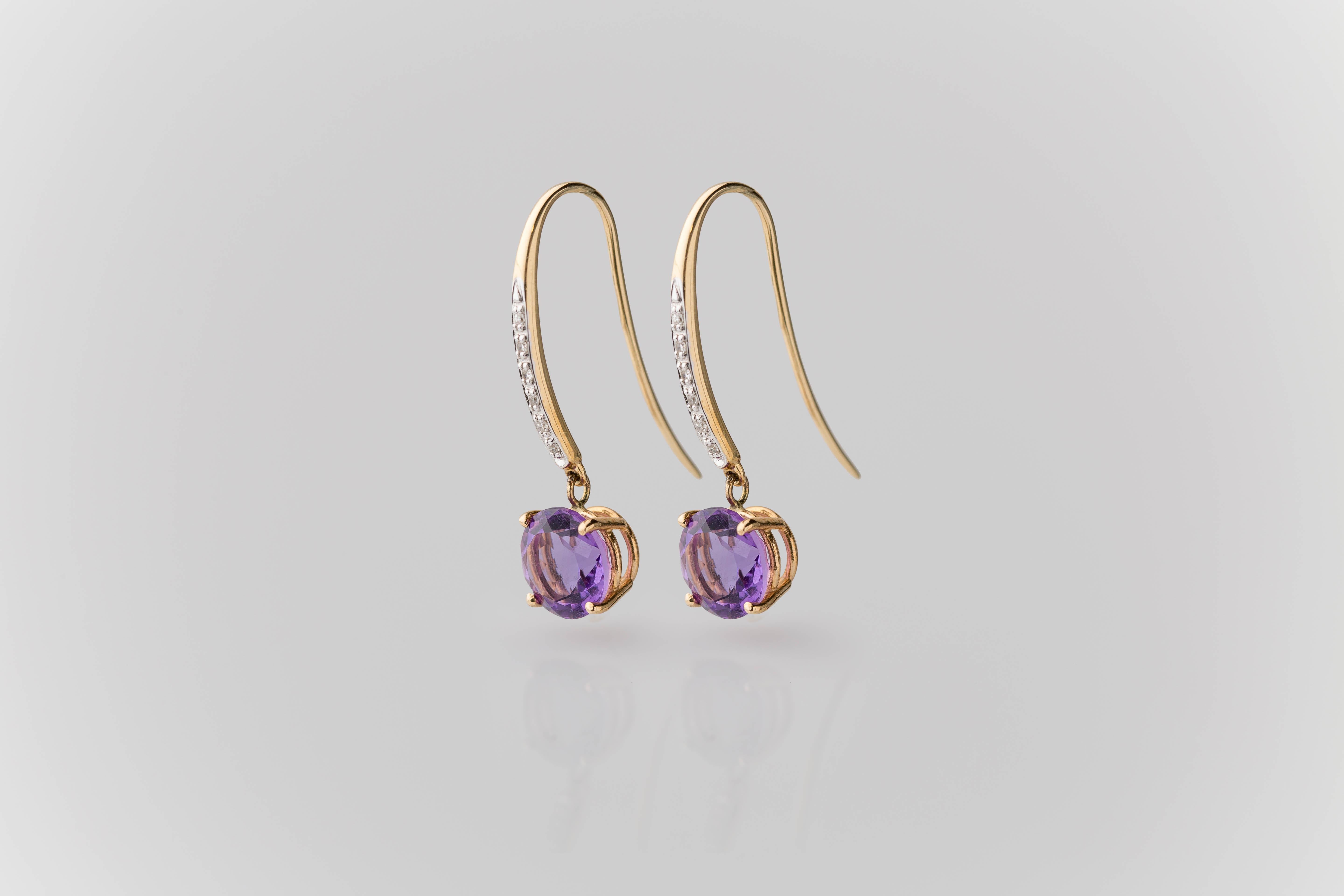 These earrings exude an undeniable beauty that captivates the eye. Crafted with meticulous attention to detail, each earring features vivid purple round brilliant-cut amethysts, totaling 3.28 carats, set on solid 14K yellow gold heavy basket-style