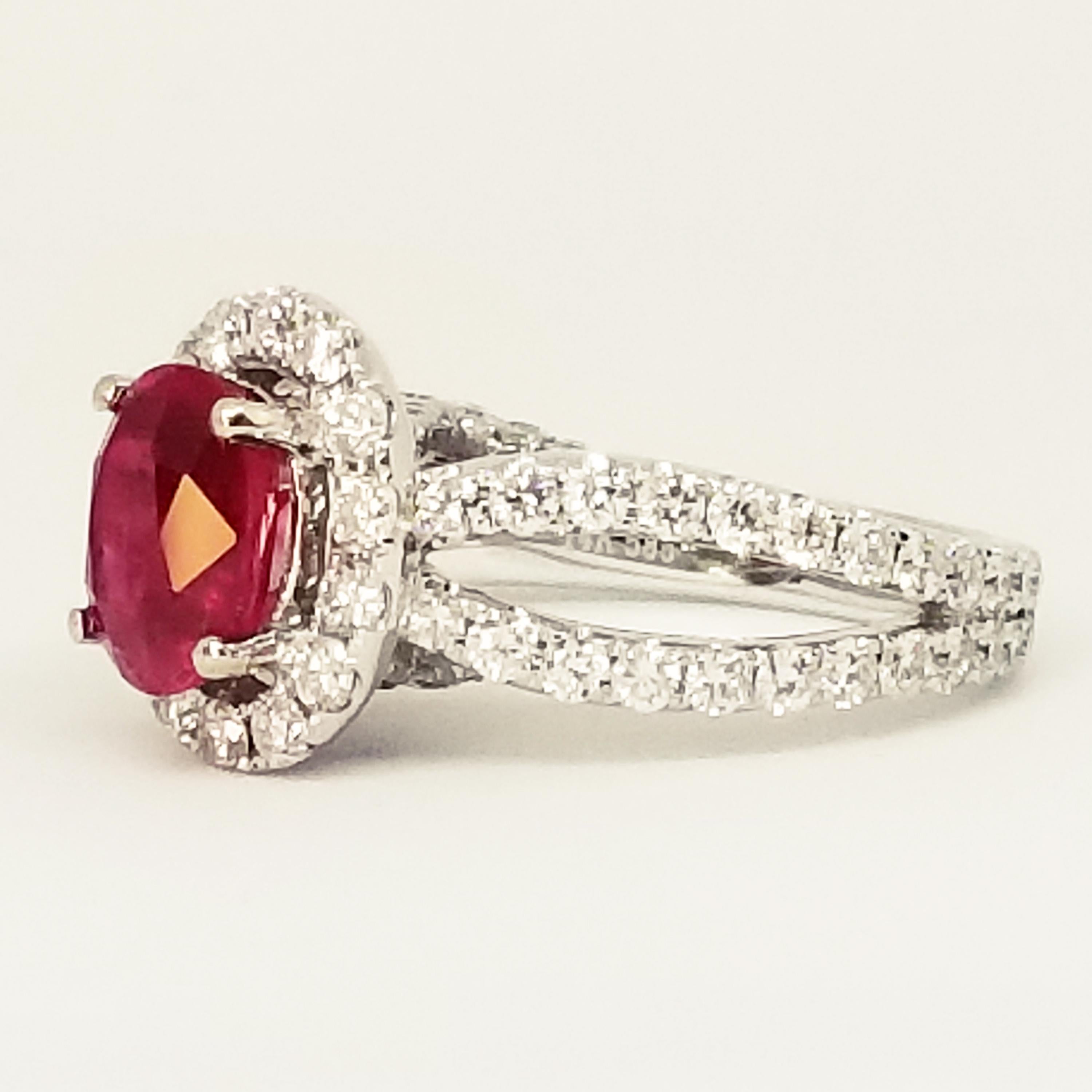 A Contemporary Engagement or Cocktail Ring is set with a 2.38 Carat Oval Ruby with Deep Color Saturation. The Gem Quality stone is set in prongs and surrounded by an oval Halo of Round Brilliant Diamonds. The Woven shoulders and sides of the ring