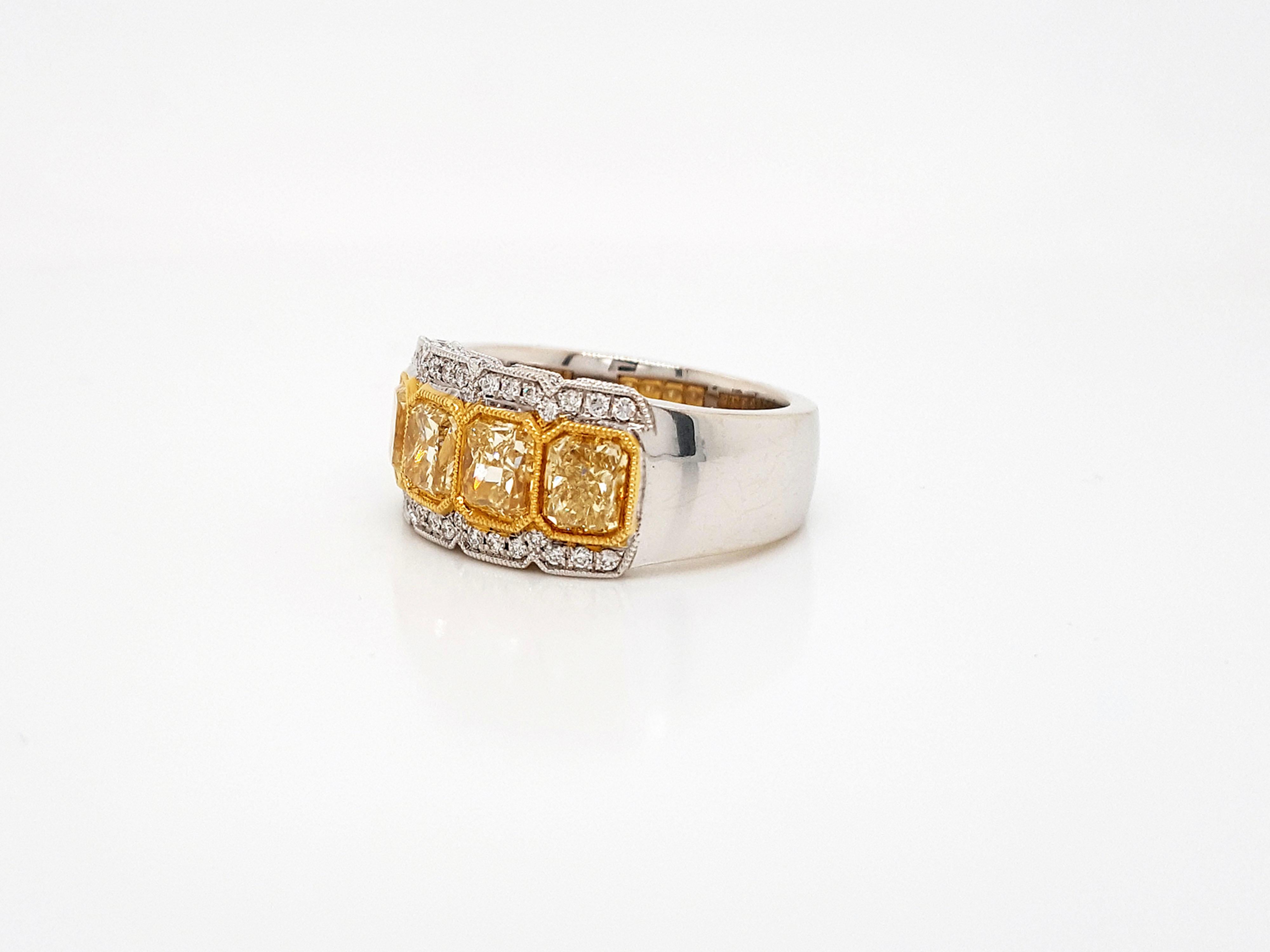 A classic and elegant 2.38 Carat Yellow Radiant Cut Four-Stone Diamond Ring in 18 Karat Gold. 
This ring set with 4 yellow radiant cut diamonds weighing approximately 2.38 carat, flanked by a 62 round brilliant 0.27 carat diamond, mounted in 18k