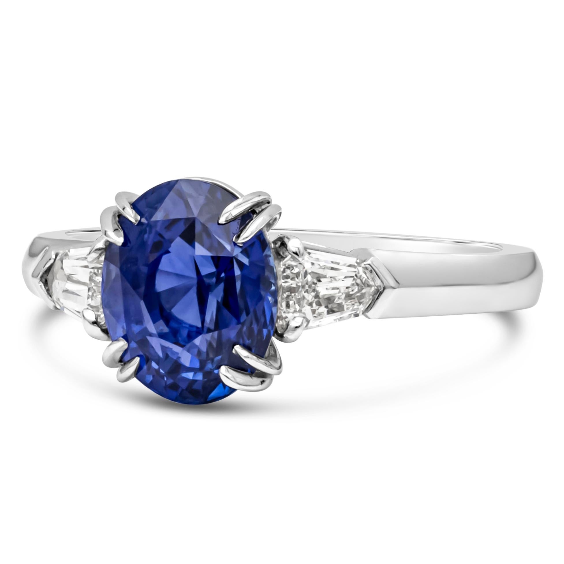 Features a gorgeous 2.38 carats oval cut natural sapphire that GIA certified as Blue in color with no indications of heating on the stone. Flanked by a bullet cut diamond side stone on each side weighing 0.29 carats total. Finely set in platinum.