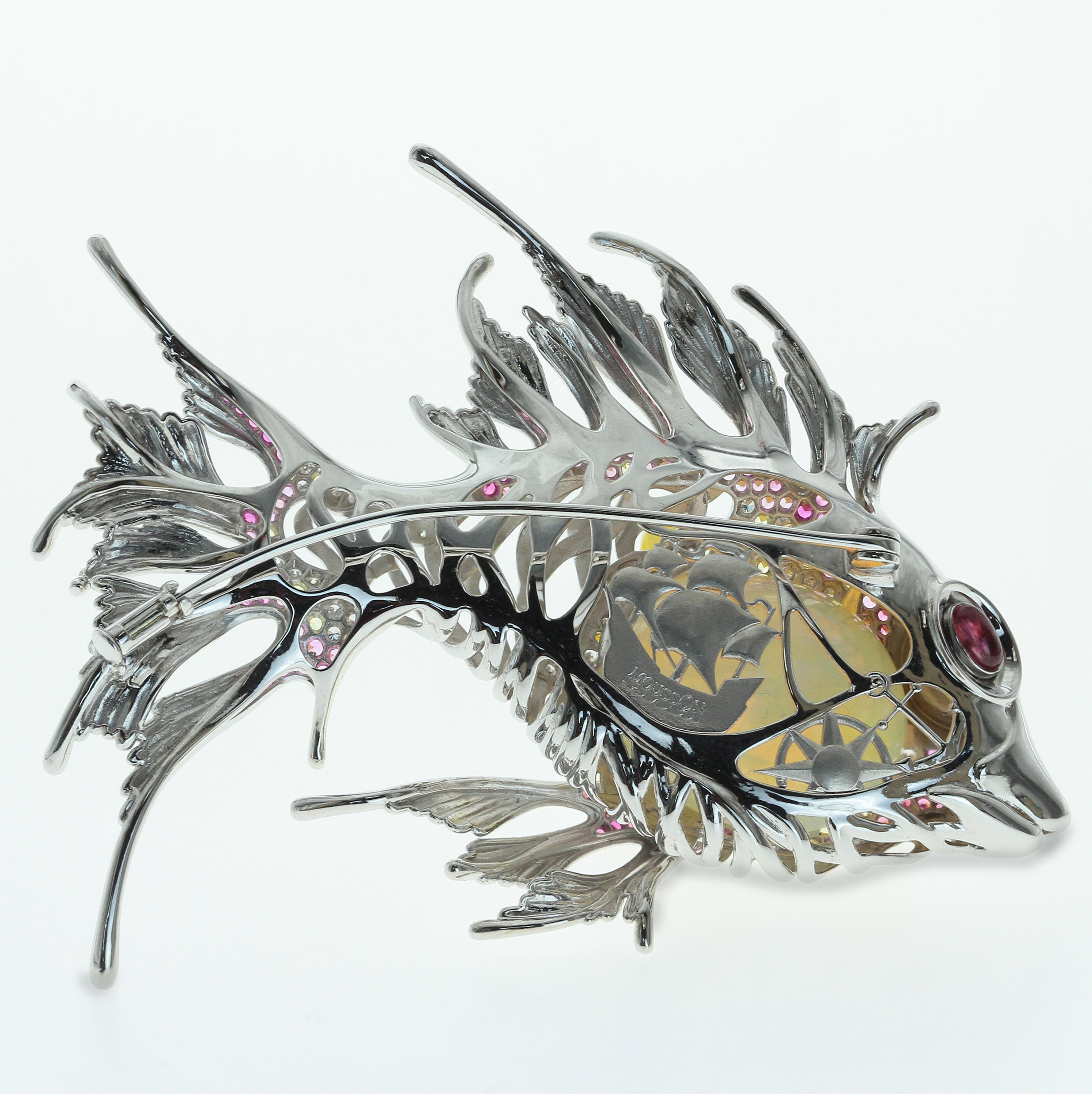 Mousson Atelier represent with prouds!
18 karat white gold Lion fish brooch. The body consists of 23.9 carat Opal, Pink and Yellow Sapphires and approximate 1 carat of Diamonds. Pink Tourmaline cabochon in the eye. High detailing, some secret story