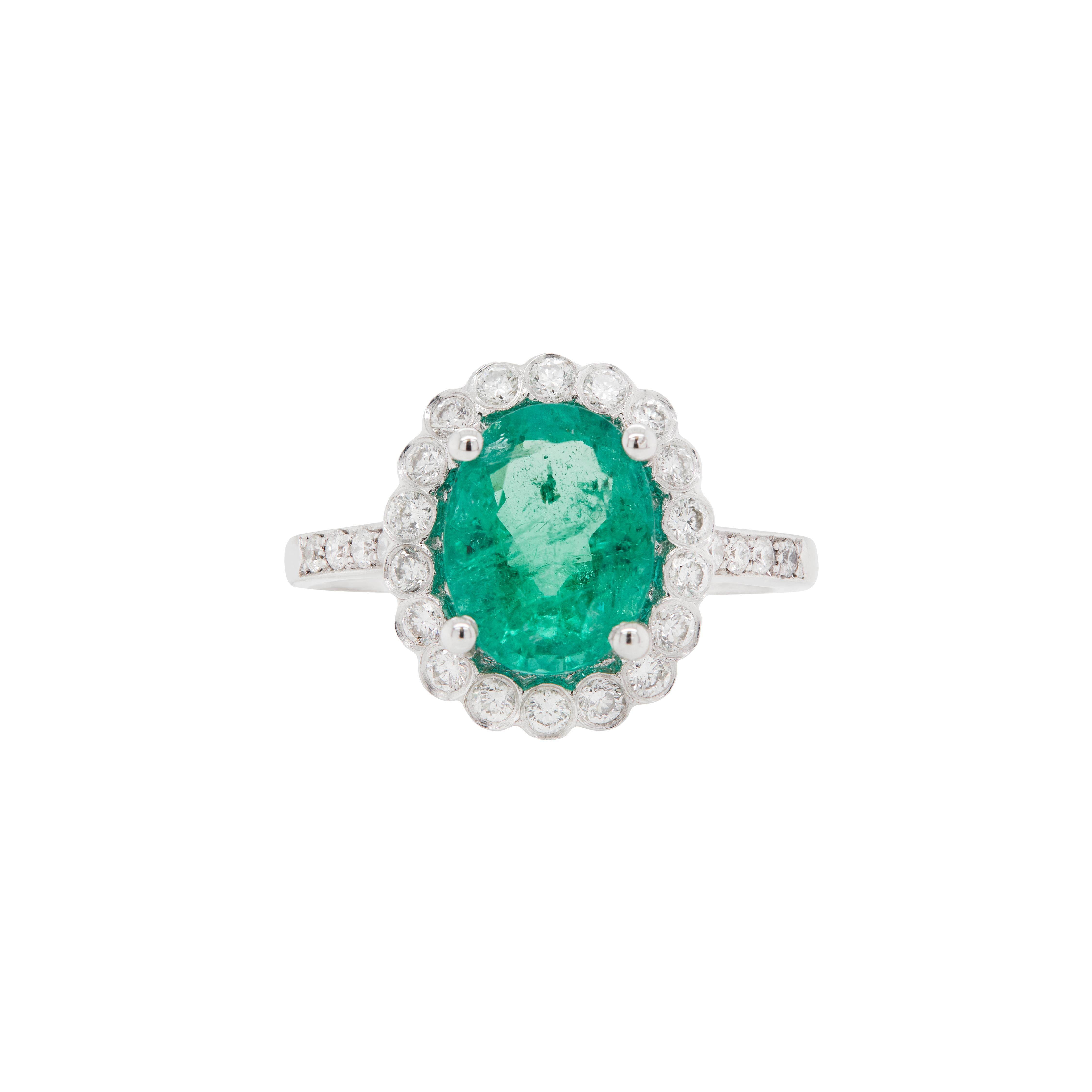 Sagen Sie JA zu dieser kühnen und doch raffinierten Variante des klassischen Clusterrings mit einem atemberaubenden ovalen Smaragd von 2,39 Karat, der in einer klassischen Fassung mit vier Krallen und offener Rückseite gefasst ist.

Das Herzstück