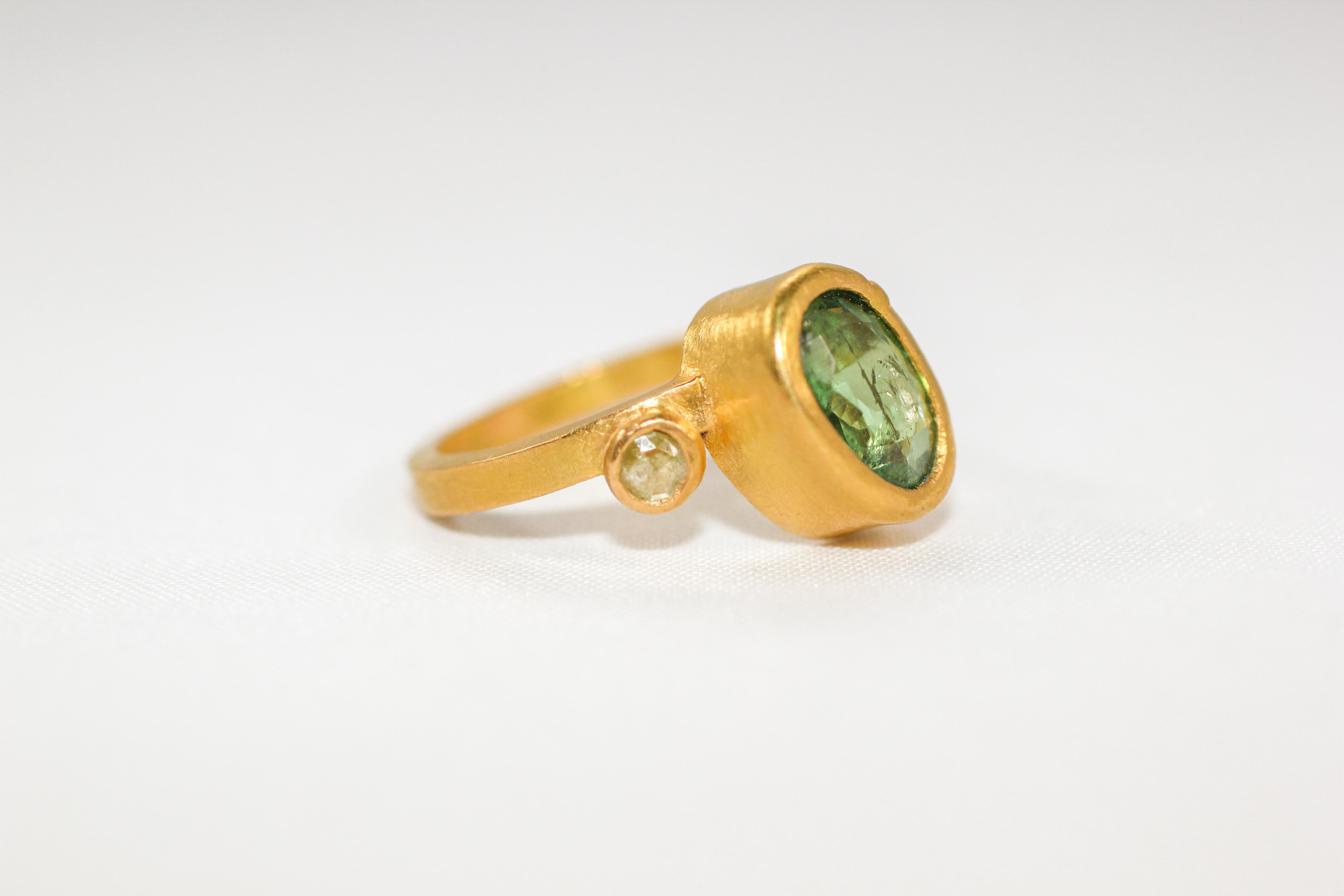 Our Popcorn Garnet Ring delivers a rich pop of green color. Whimsical bridal or stackable fashion three-stone ring in recycled 22k textured gold, featuring green Russian demantoid garnet flanked on both sides by two yellow rose cut diamonds. The