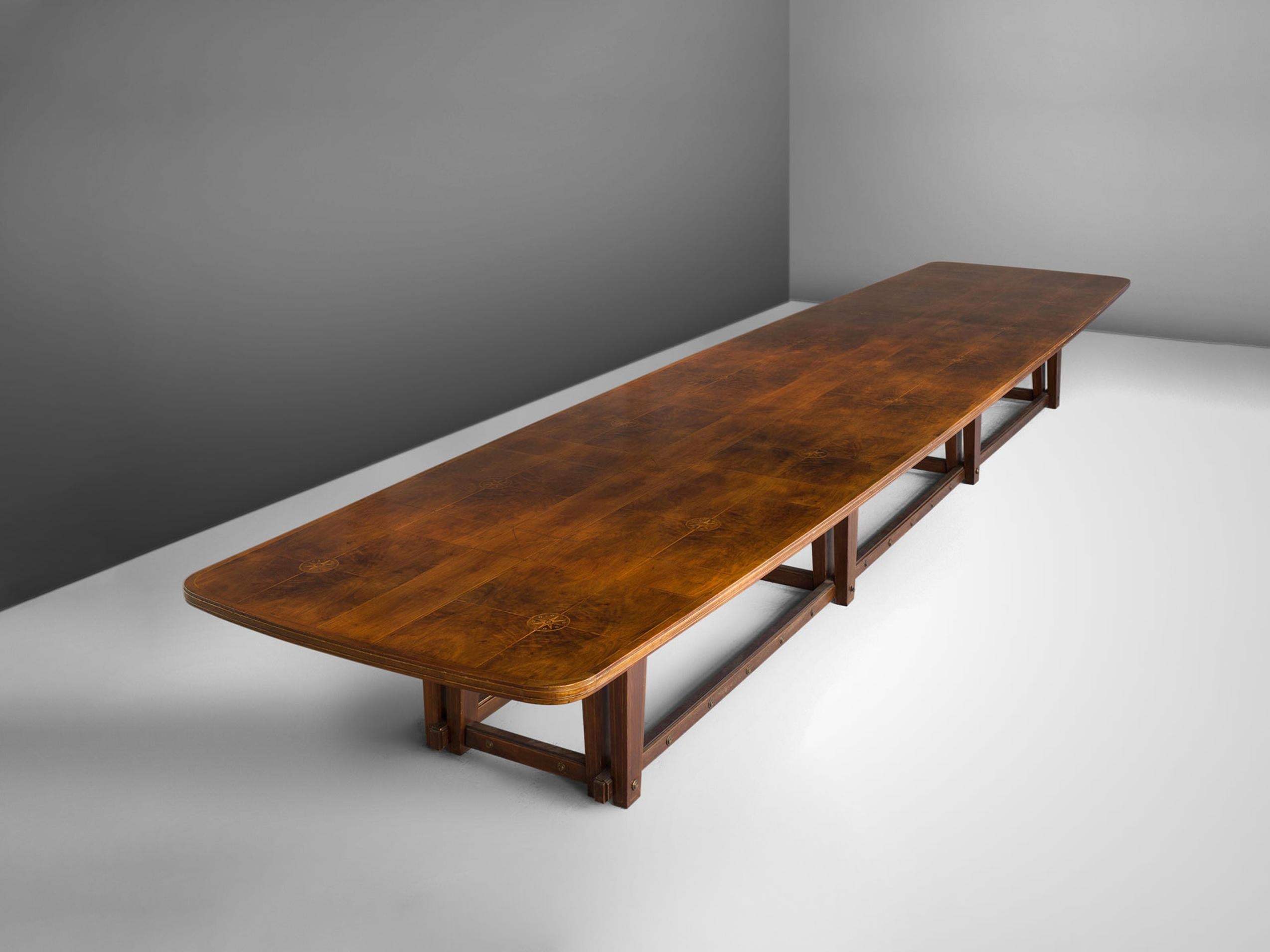 Conference table, walnut, brass, Europe, 1940s

Extremely large conference table in walnut. The top shows beautiful inlaid wood that has a sun or starlike motif. A geometric pattern is created due to horizontal and vertical lines. The large top is