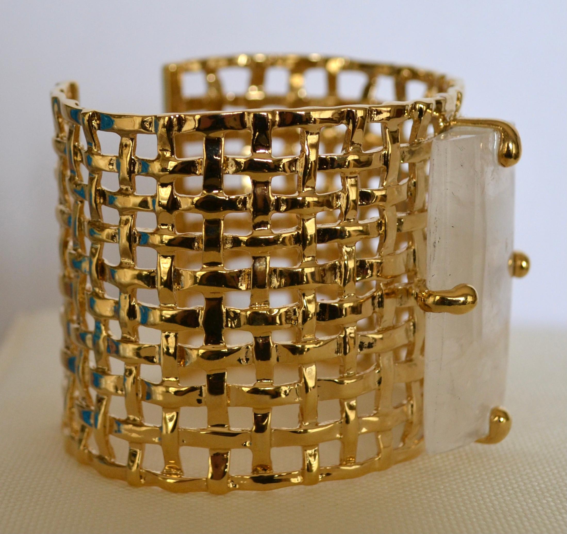 24-carat gilded bronze metal designed in a basket weave motif  adorned with a sizable rectangular rock crystal. The size can be adjusted.
This designer was Robert Goossens personal assistant in all of his creations. She worked by his side for 20