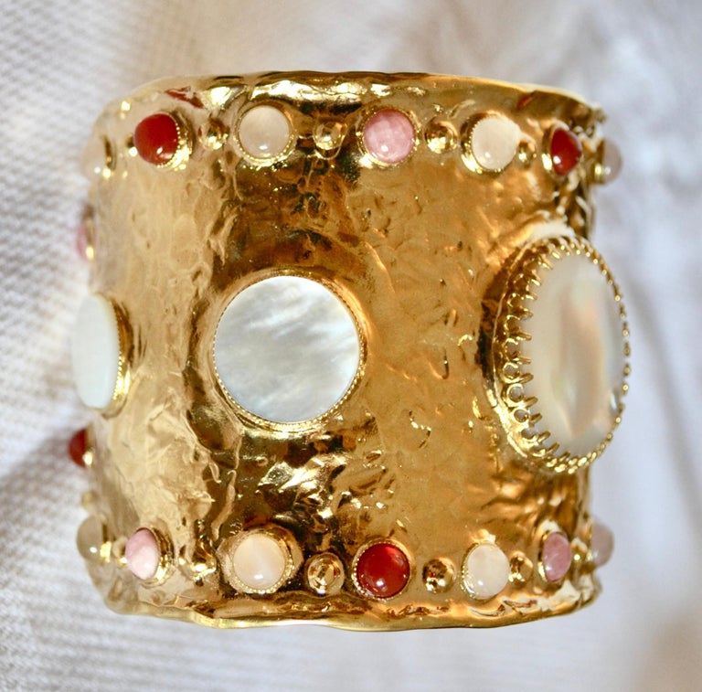 24-carat gilded bronze metal with mother of pearl, moonstone, pink quartz and cornelian. The metal is hand hammered.
Opening is 1.4”
The size can be adjusted.
This designer was Robert Goossens personal assistant in all of his creations. She worked