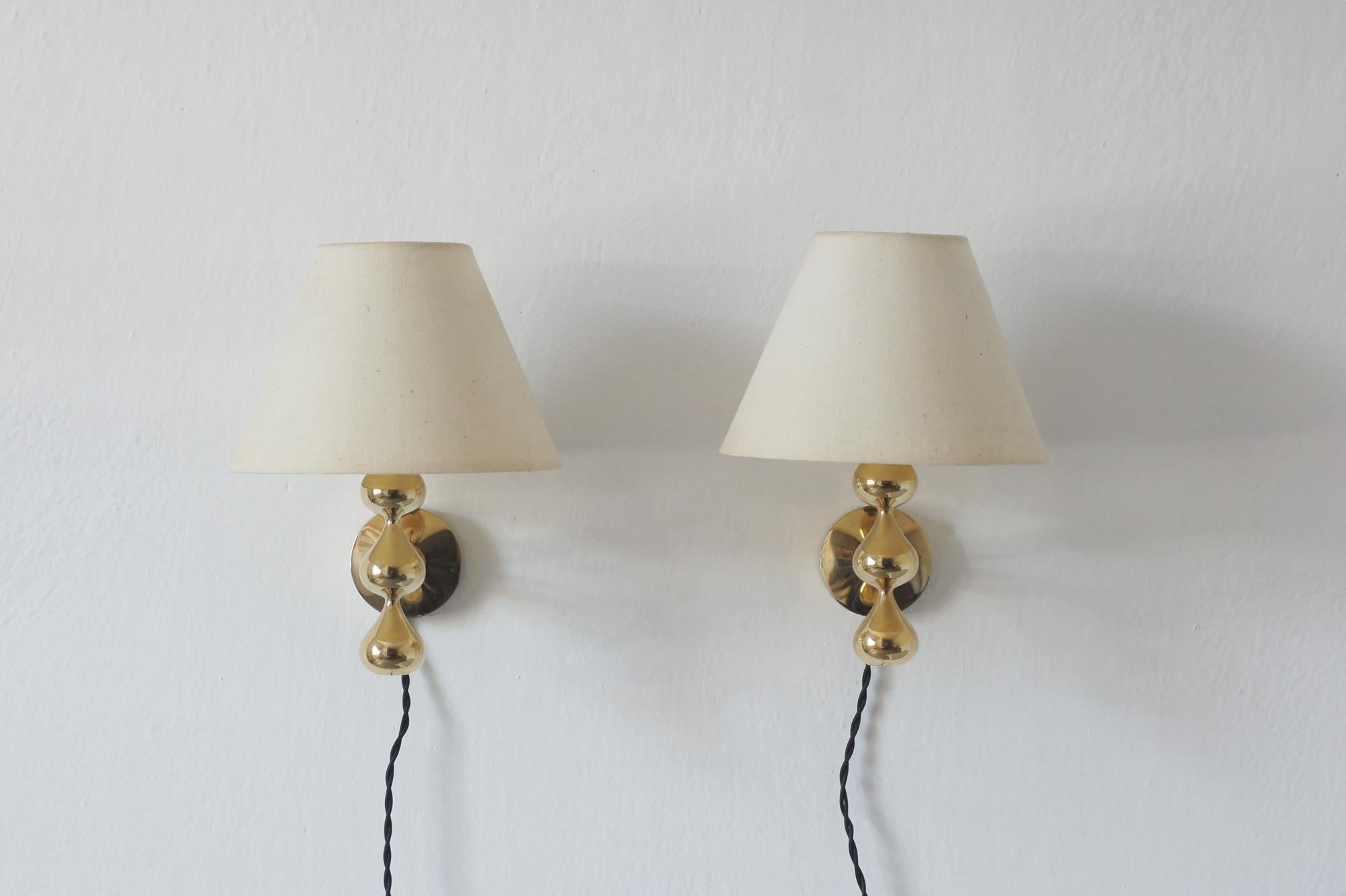 Las lámparas de pared con pantallas diseñadas por Hugo Asmussen son ejemplos sutiles pero sofisticados de la iluminación danesa de los años 60 y 70, que combinan el detalle artesanal con el minimalismo funcional. Su característica base en forma de