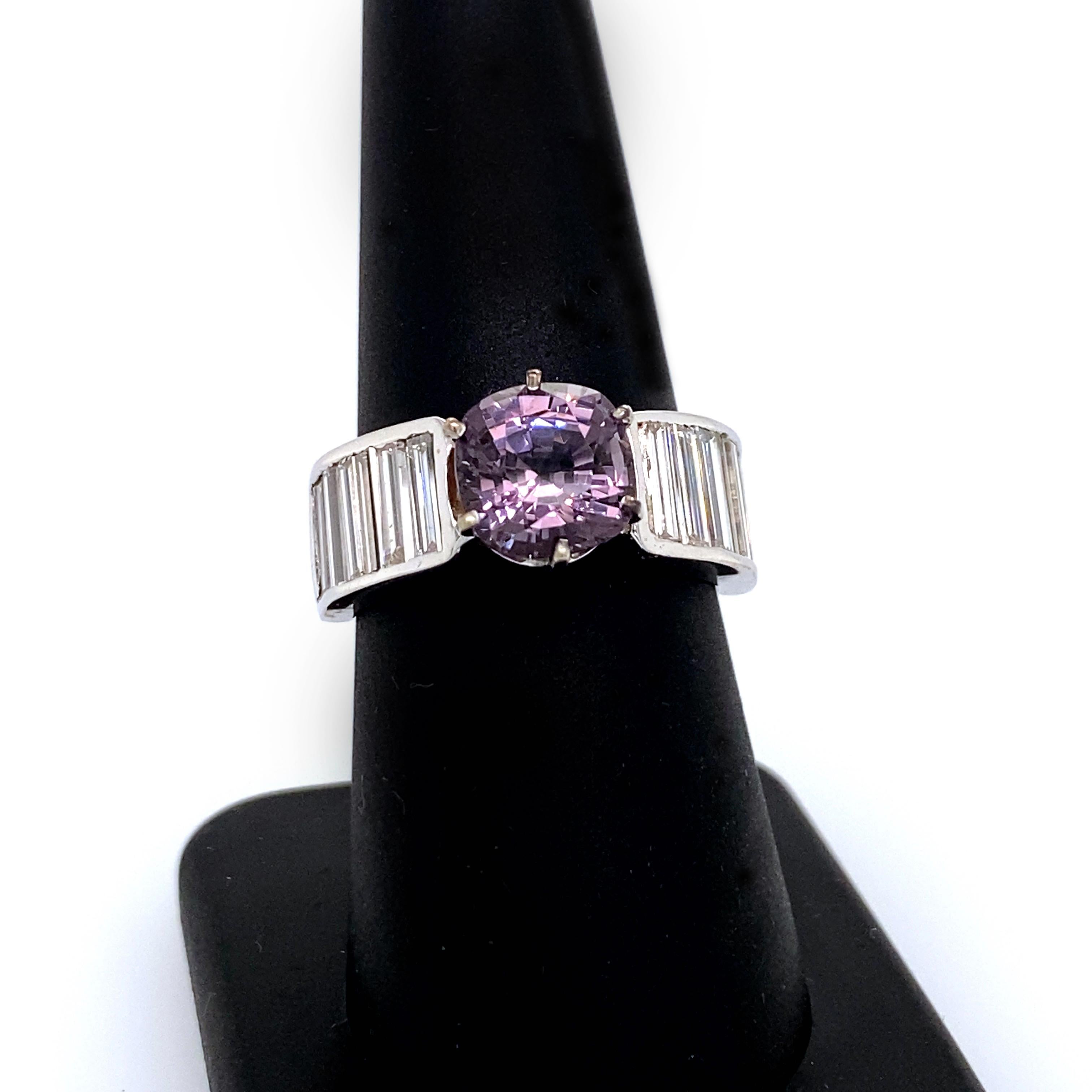 This bold, gorgeous and modern ring by Eytan Brandes features a luscious, dusty mauve spinel girded by 14 extra-long straight channel-set baguettes.  

The cushion-shaped, mixed cut spinel is an exquisite and elegant shade of pale purple (it looks