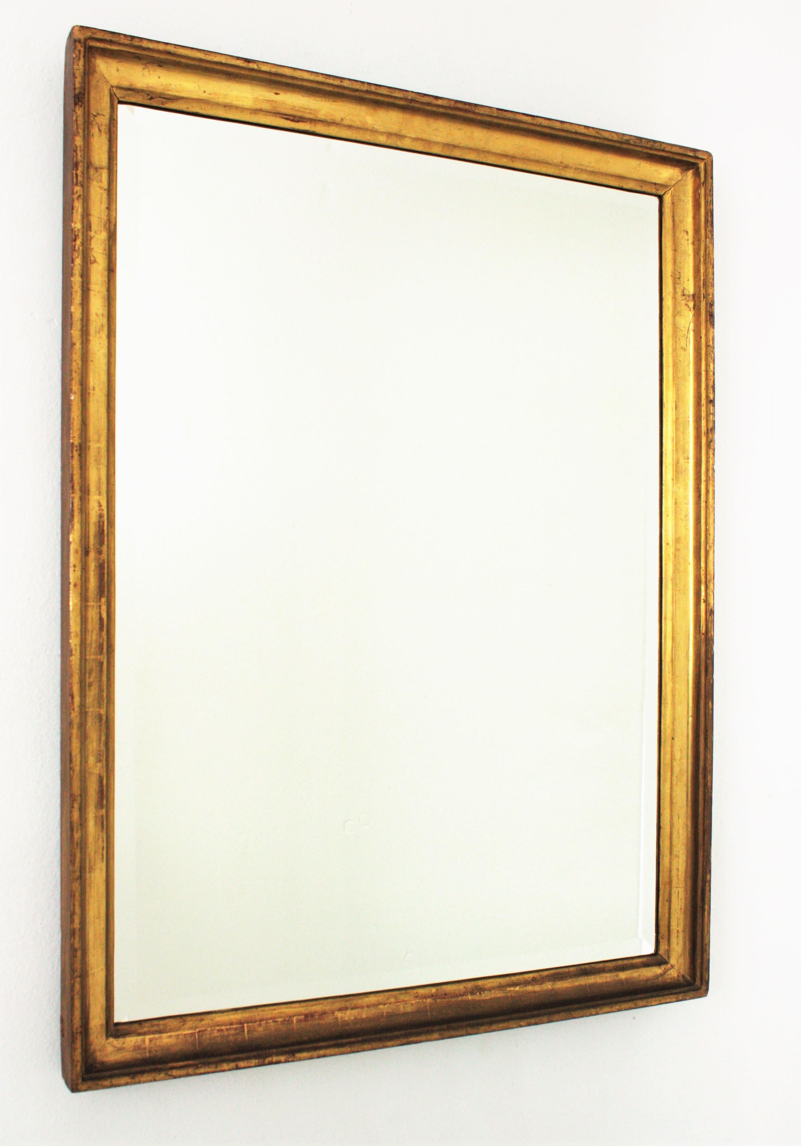 Elegant Spanish 19th century gold leaf giltwood rectangular mirror with beveled glass.
Empire style.
Made of carved wood, gesso and 24-karat gold leaf finish. It has a nice aged patina.
It will be a good choice for any bedroom, bathroom, dressing