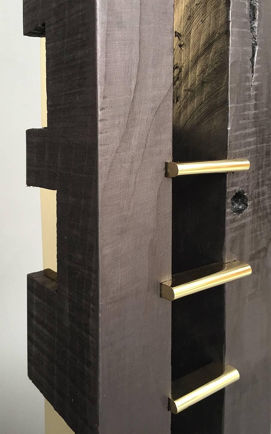'24-karat black' is a totem of seduction, critique and reflection. Offering guidance through the difficult passage of time - dug out grooves represent trenches, uneven polished brass steps cunningly promise Jacob’s ladder, and the wood beam looks