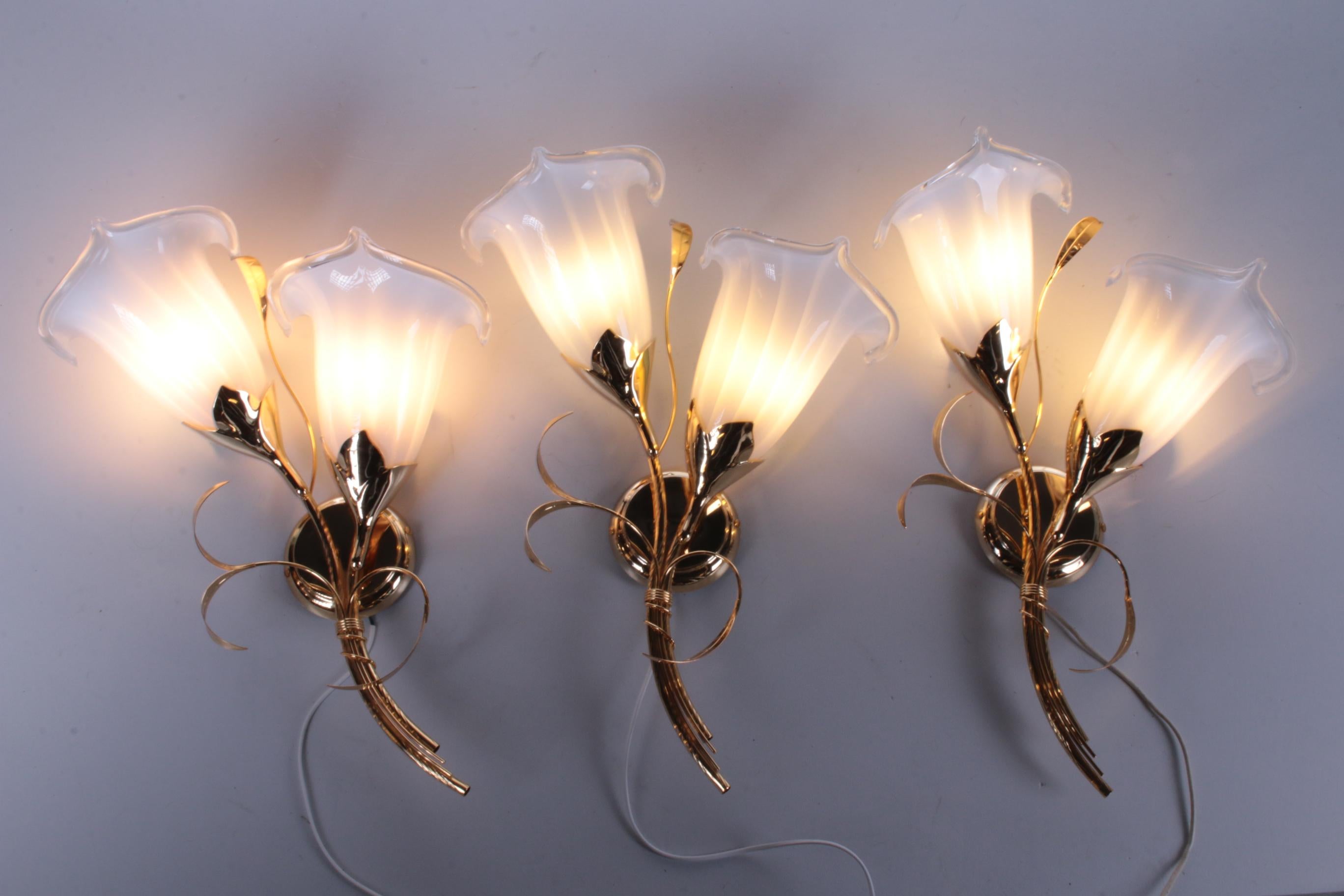 24 kt gold-plated tulip glass wall lamps Italian design 1970

This is a beautiful Hollywood Regency set of three wall lamps.

Made of gold colored metal with beautiful Murano glass shades.

Can be mounted on the wall.

We only sell these