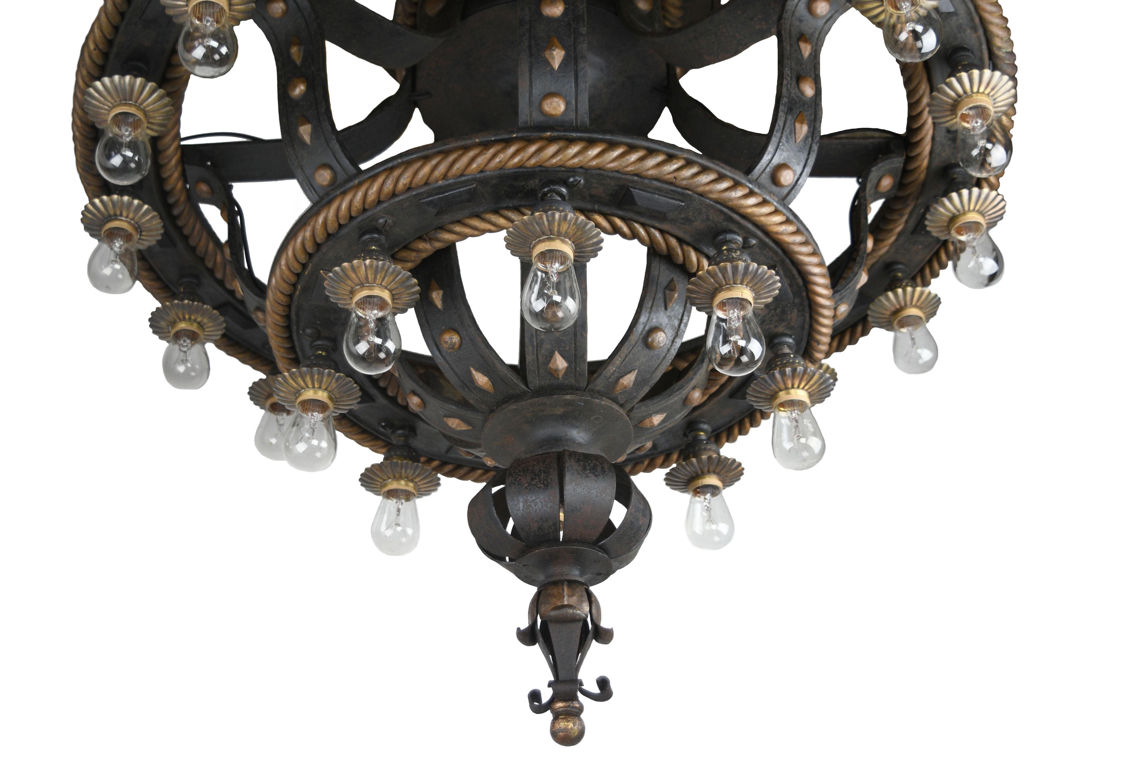 This enormous and exquisite flush mount chandelier features many decorative flourishes and 24 light bulbs making it an extremely illuminating fixture. The sturdy cast iron frame is highlighted by numerous brass floral designs and braided circles.