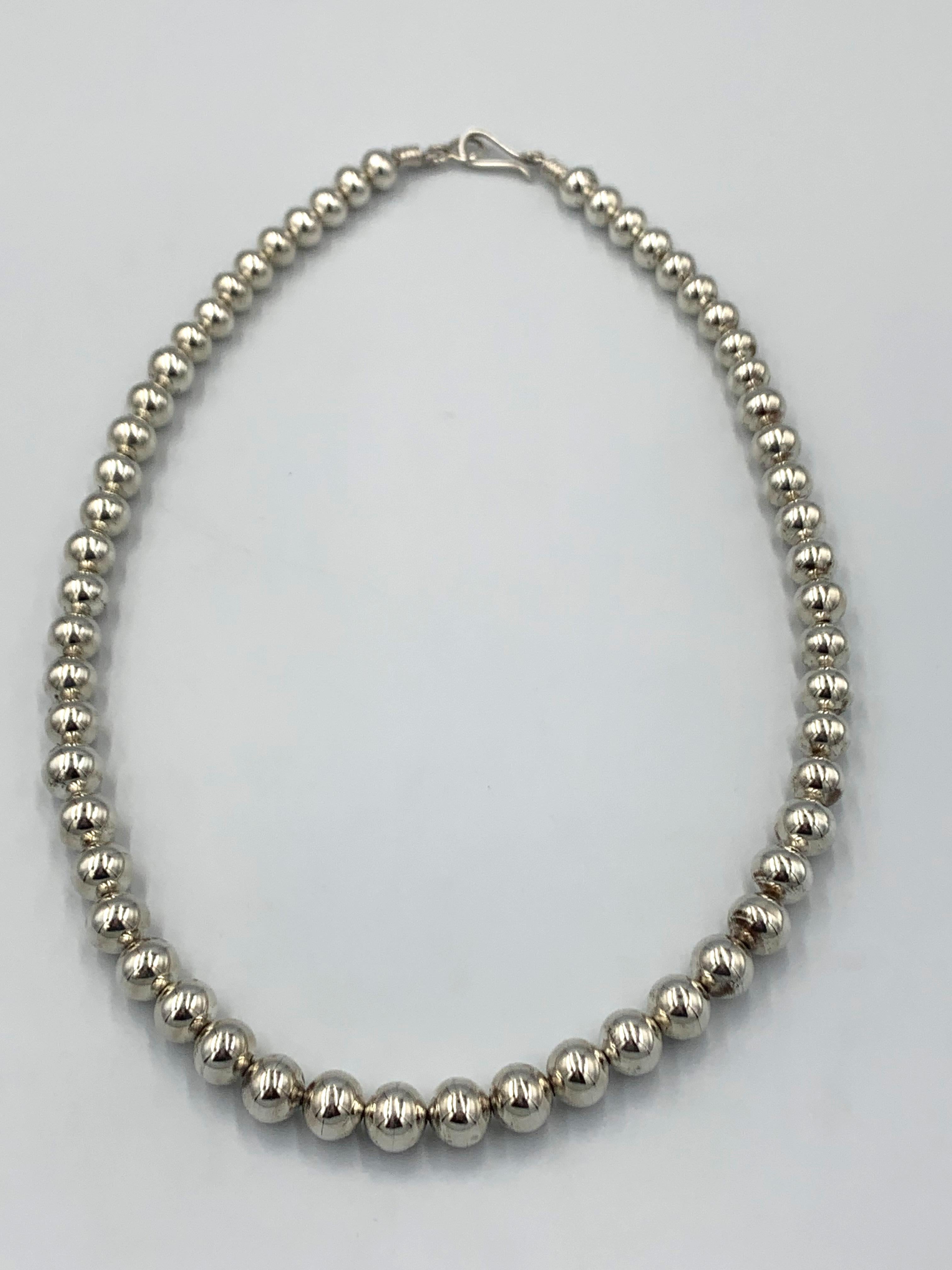 Collar de una sola hebra de plata de ley con cuentas de perlas navajo hechas a mano en tamaños graduados con un acabado pulido. 

Longitud del collar: 24
Diámetros de talón: 3/8