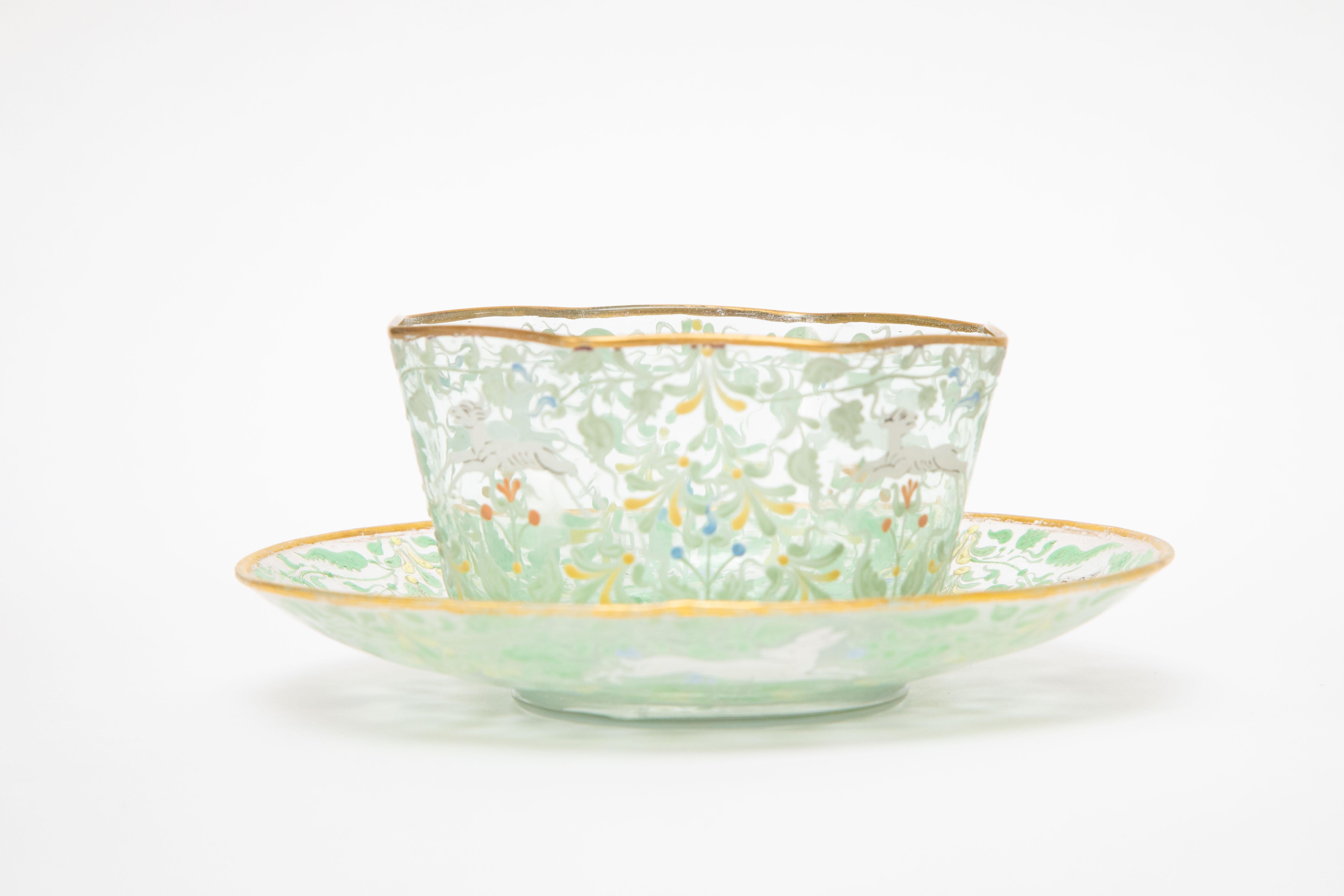 An exquisite set of 12 bowls and 12 under plates from the Venetian art glass island of Murano. This fanciful set has a beautifully blown bowl with very detailed hand painting surround of whimsical flora fauna and animals. A lovely color of pale aqua
