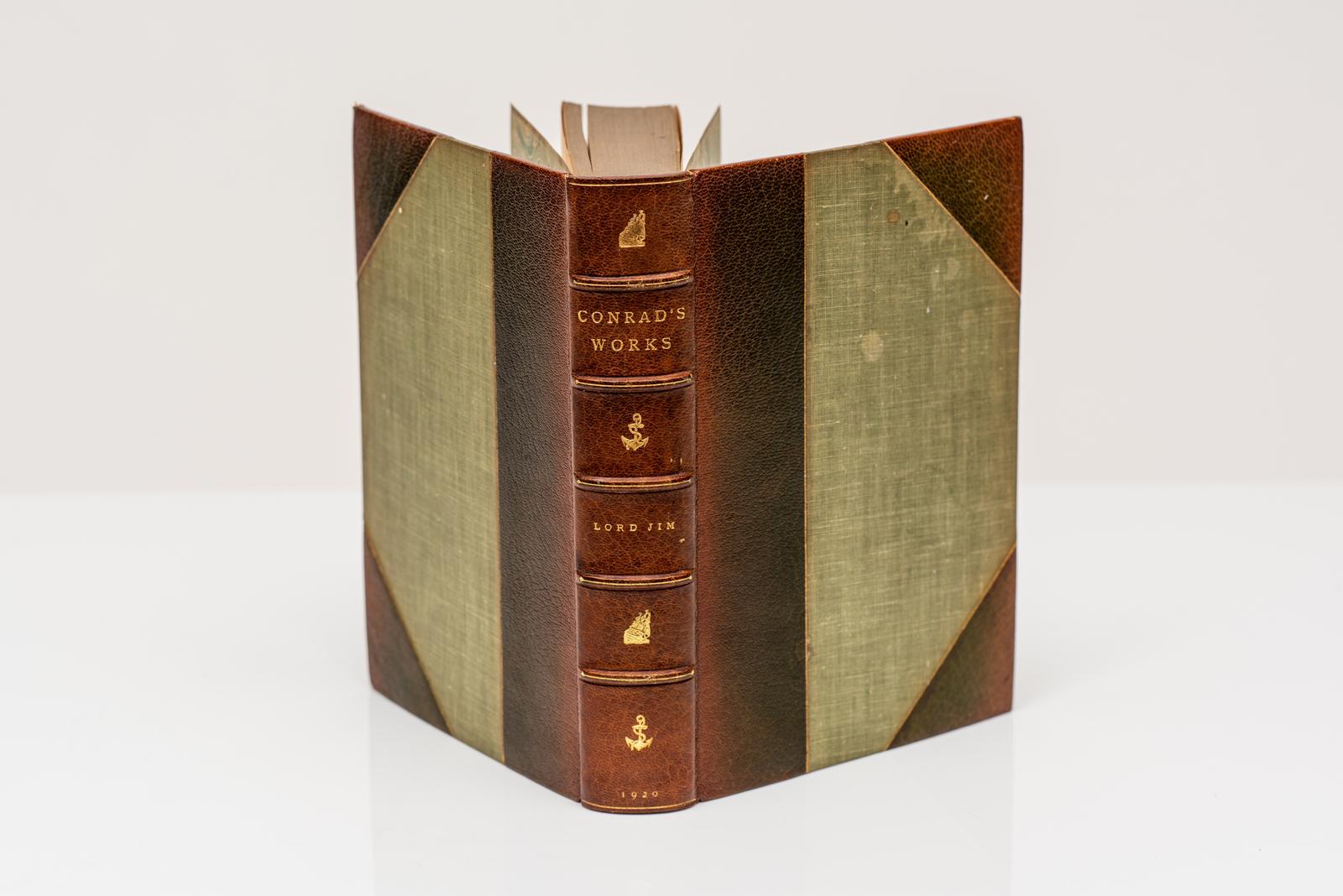 24 volumes. Joseph Conrad, Les œuvres Édition limitée et signée. Relié par James Macdonald Co. en maroquin fauve 3/4 et planches de lin vert. Les couvertures et les dos à bandes surélevées sont dorés avec des détails nautiques sur le dos. Bords