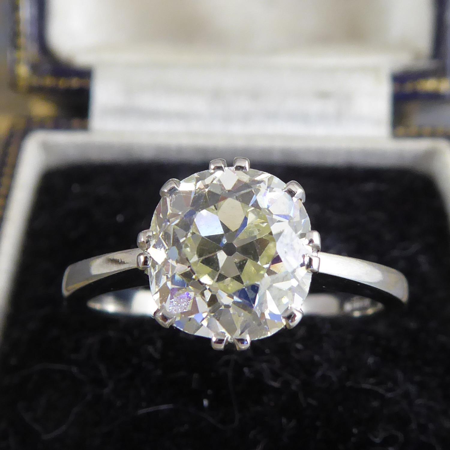 A diamond set single stone ring consisting of a cushion-shaped, old European cut diamond, measuring 8.1mm x 7.80mm x 5.49mm deep, weighing 2.40ct and with colour and clarity assessed as M/N and VS.  The diamond is held in a claw/split claw ring