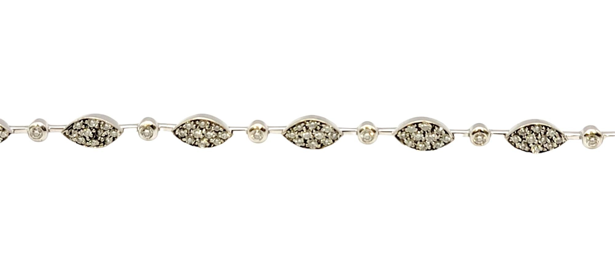 This elegant diamond link bracelet will wrap your wrist in modern beauty. Simple yet chic, the marquis shaped stations are filled with sparkling pave diamonds while a single round diamond in between the links adds a little extra shimmer and shine.