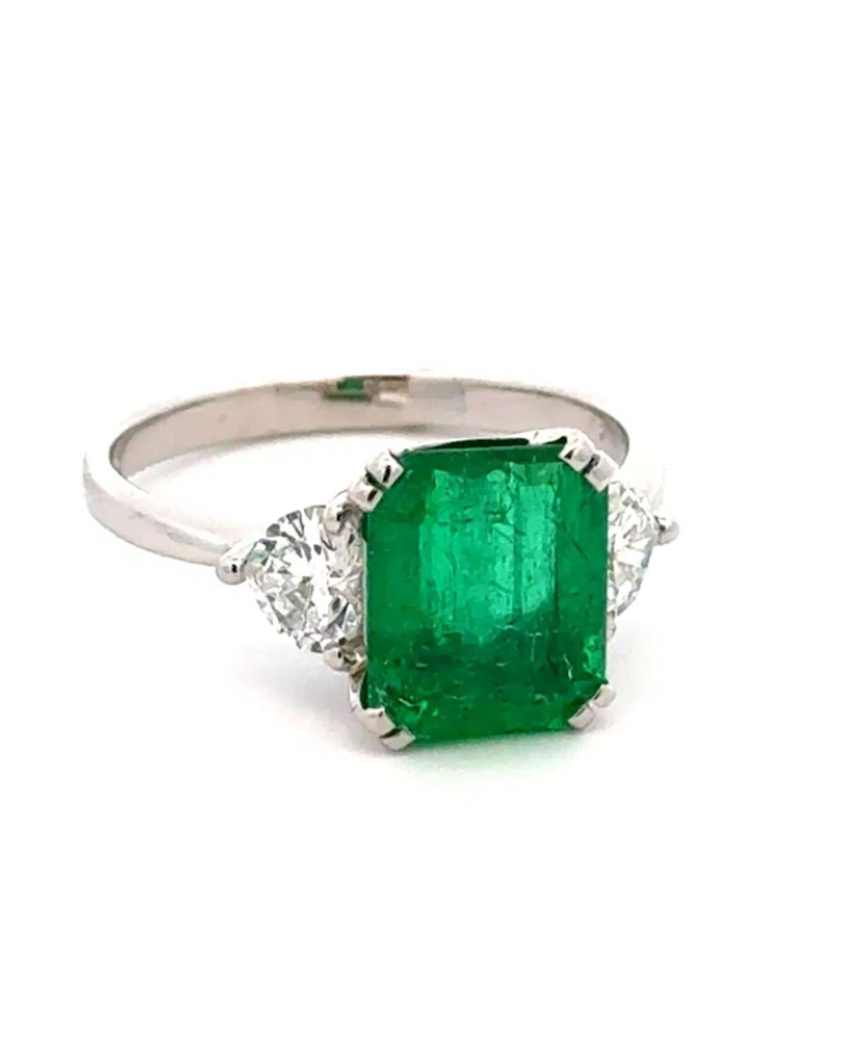 Tout simplement magnifique ! Bague de cocktail vintage en or à 3 pierres, émeraude et diamant. Au centre, une émeraude de 2,40 carats sertie à la main, chaque côté étant rehaussé de diamants en forme de cœur, pesant environ 0,66 ctcw. Monture en or