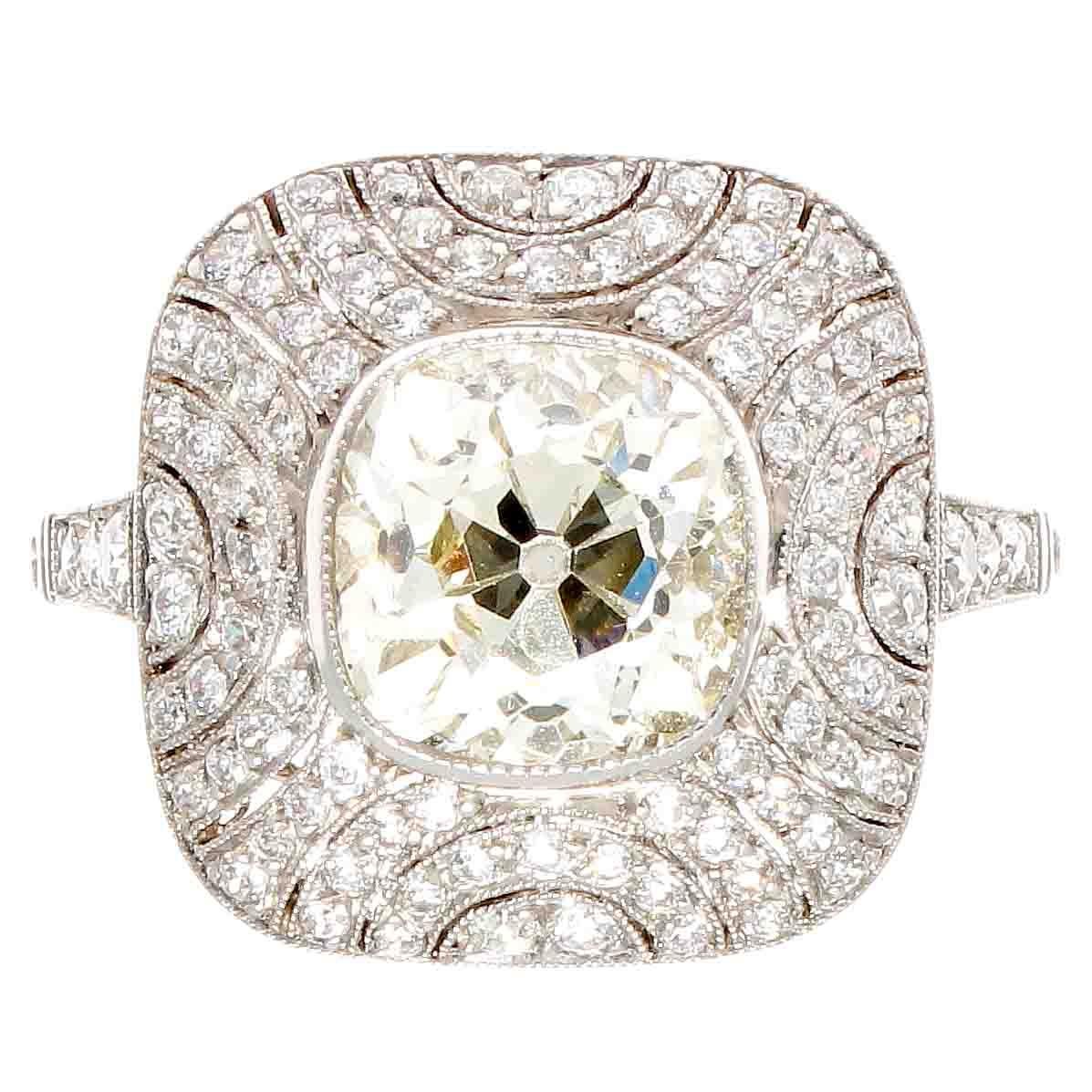 An original old mine cut diamond from the 1920’s. The well cut diamond is set in a modern art deco inspired ring. The diamond weighs 2.40 carats and is M color, VS1 clarity. Hand crafted in platinum featuring numerous near colorless diamonds. 
Ring