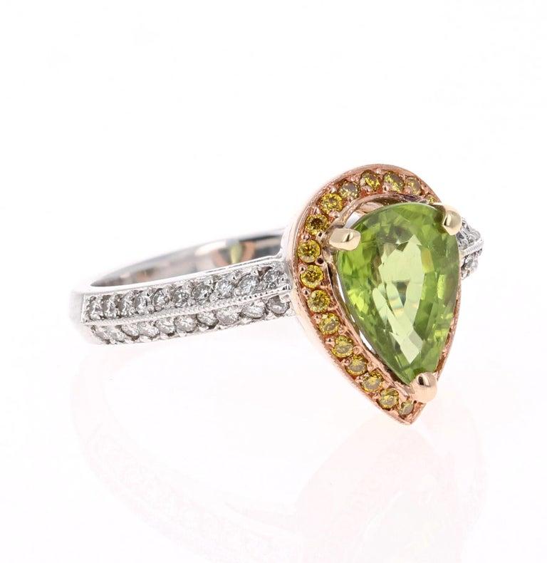 This beautiful ring has a Pear Cut Peridot in the center that weighs 1.83 carats. The ring is surrounded by a cute halo of 22 Round Cut Natural Yellow Diamonds that weigh 0.25 carats and 40 Round Cut White Diamonds along the shank that weigh 0.32