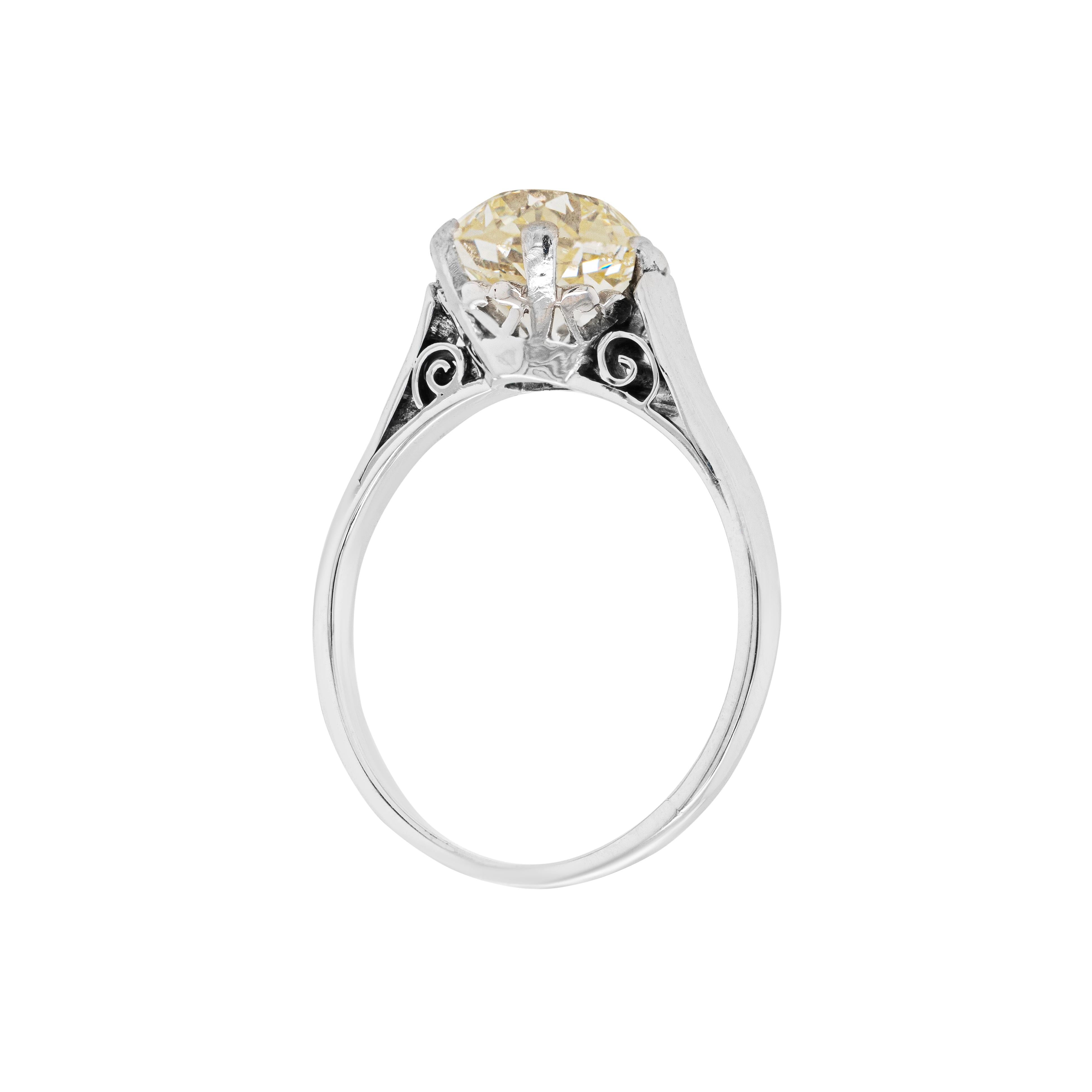 This spectacular antique solitaire engagement ring features a beautiful 2.40ct Victorian old mine cut diamond neatly set at its centre in a six claw, open back platinum collet. Delicate swirls add romantic accents to the sides of the shoulders and