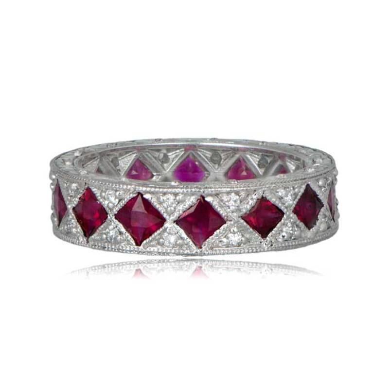 An exquisite vintage-style wedding band featuring French-cut rubies and round diamonds. The rubies, bordered by milgrain and platinum, are complemented by a diamond positioned between them at the top and bottom of the band. Fine, detailed engravings