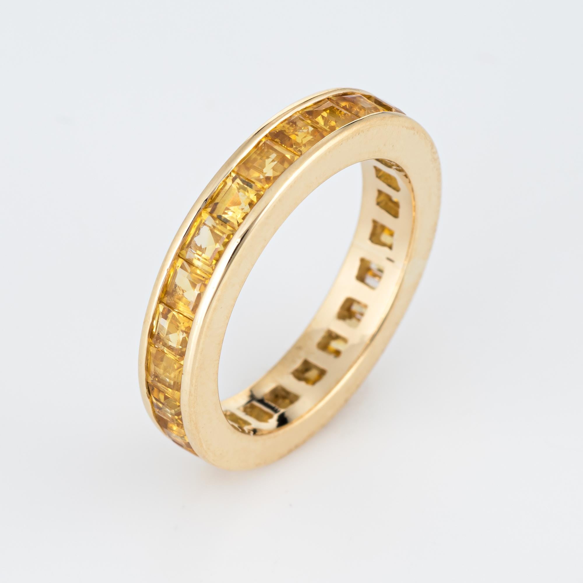 Elegant estate yellow sapphire eternity band crafted in 18 karat yellow gold. 

24 square emerald cut yellow sapphires are estimated at 0.10 carats each, totaling an estimated 2.40 carats. The sapphires are in excellent condition and free or cracks