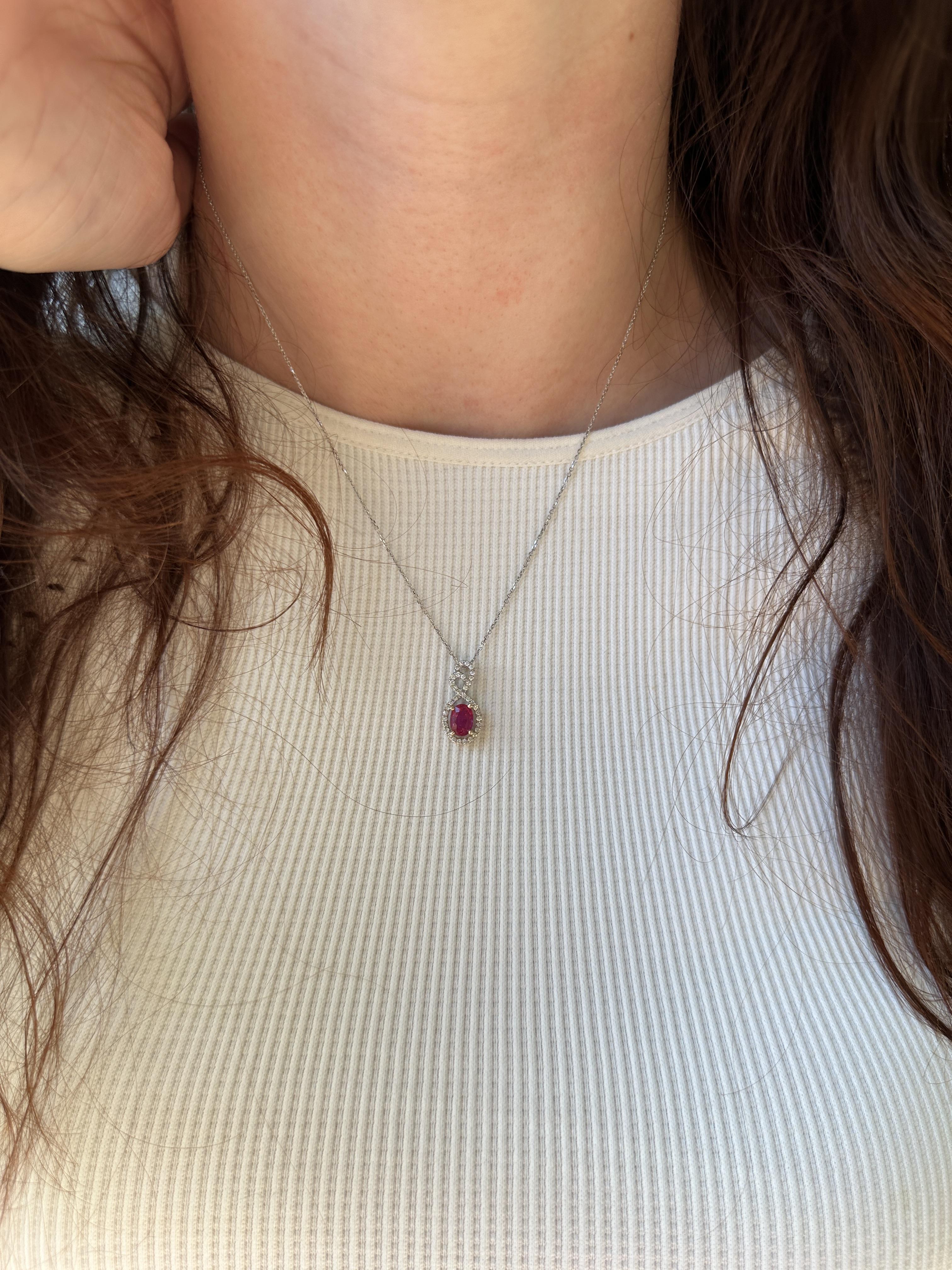 Un magnifique rubis de Madagascar pesant 2,40 carats, serti dans une forme ovale de 7x5mm. Le rubis est entouré d'un halo étincelant de diamants de 0,20 carat, créant un cadre élégant qui met en valeur la teinte rouge profond du rubis. Le pendentif