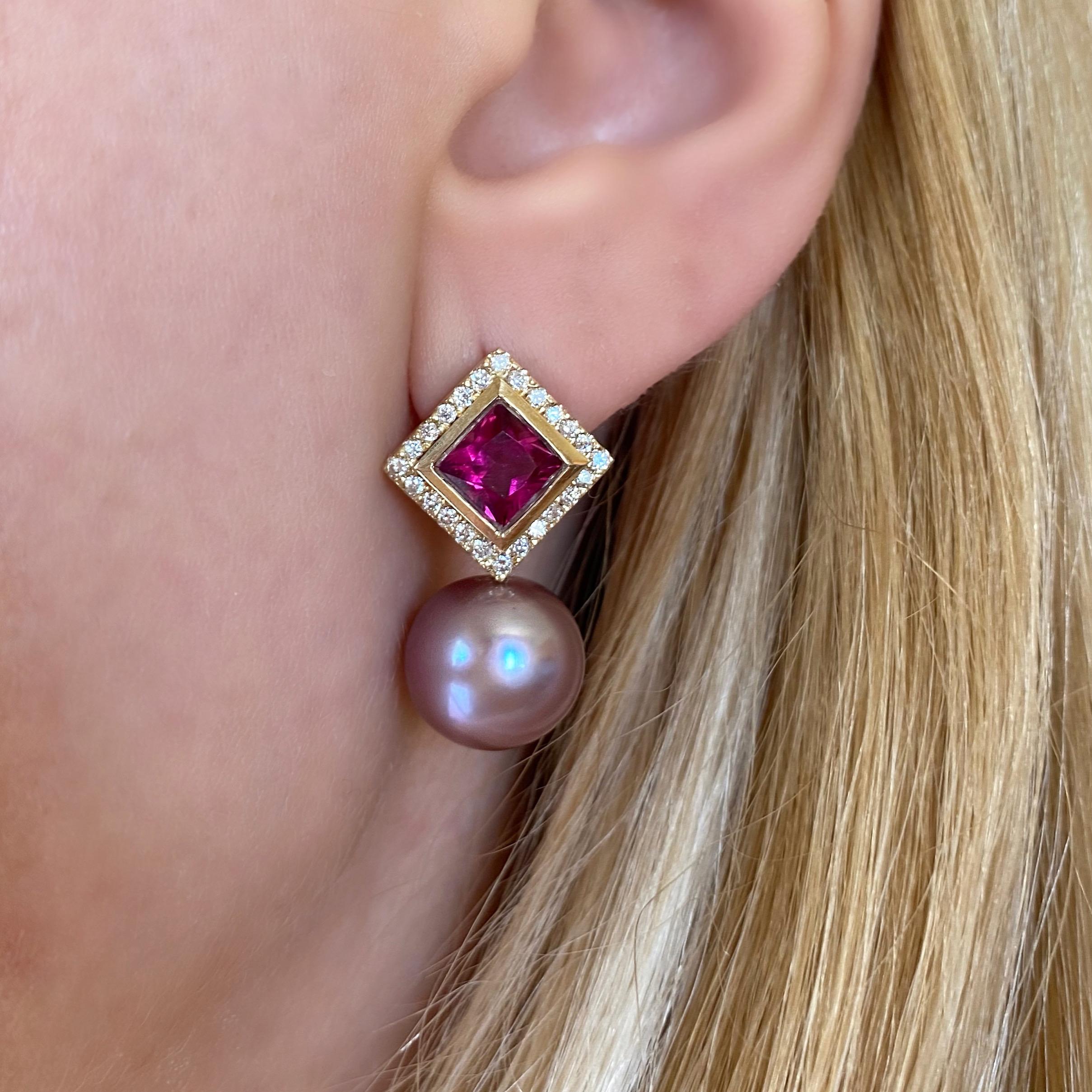 These one-of-a-kind earrings by Michelle Massoura are made in 18Karat Yellow Gold and set with a pair of princess cut Rubellites, surrounded by a bezel frame and a halo of glimmering natural diamonds. The earrings are strung by a lustrous pair of