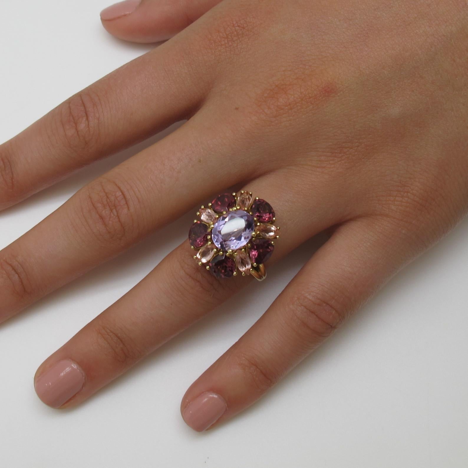 This blooming multicolor ring makes a statement that demands attention whenever worn! It’s center “Rose de France” color amethyst measures 10.02x8.20x4.96mm  and weighs 2.41 carats. It is encircled by 5 pear shaped garnets (4.25 carats total