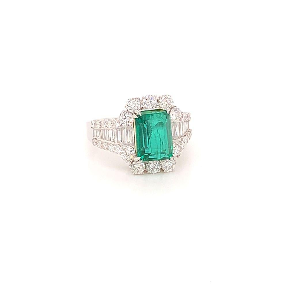 This Uniquely exquisite ring features a Stunning Emerald cut Emerald weighing approximately 2.41 Carats at its centre, surrounded by a combination of scintillating round brilliant and baguette cut Diamonds weighing a total of 1.44 Carats and set in