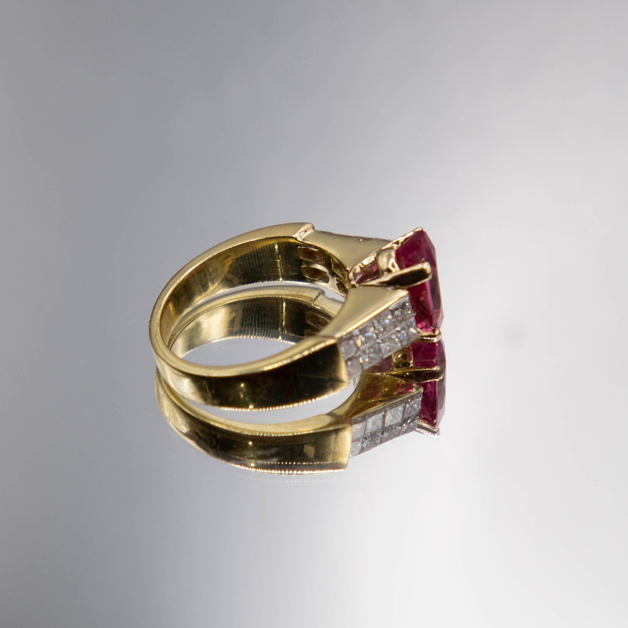 The 18k yellow gold rings features a modified 2.41 carats cushion oval hot BUBBLE GUM pink tourmaline radiating atop special invisible-set princess cut diamonds having E color and VS clarity. Total diamond weight is 1.00 carats. 