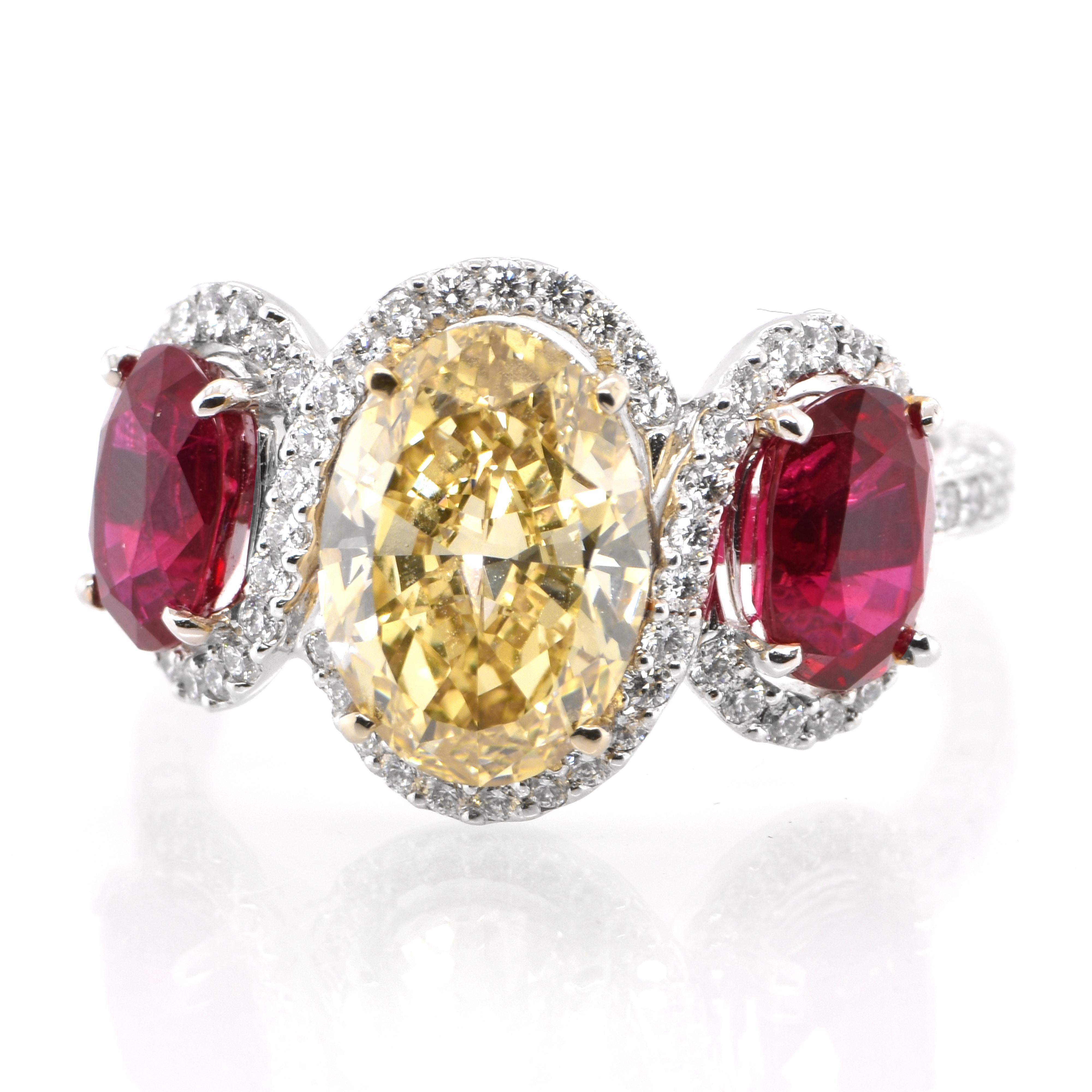 A three stone ring featuring a 2.417 Carat Natural Fancy Brownish Yellow Diamond and GIA Certified Pigeon Blood Ruby Ring set in Platinum. Diamonds have been adorned and cherished throughout human history and date back to thousands of years. They