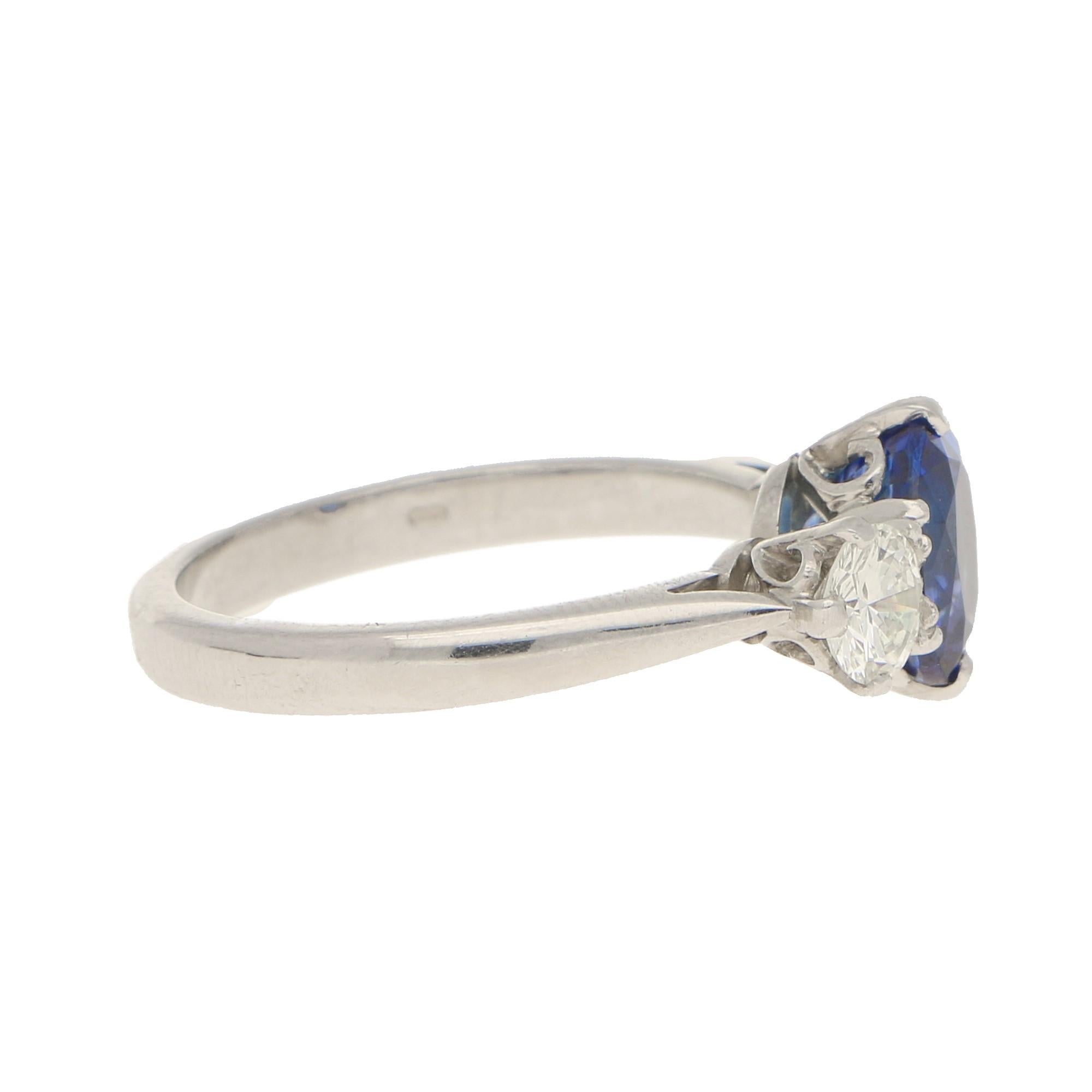 A classic sapphire and diamond three stone ring. The central oval sapphire is 2.41cts, a very beautiful rich blue stone which is complimented by two round brilliant diamonds. The diamonds are 0.3cts and 0.37cts, G/H colour and VS clarity.
