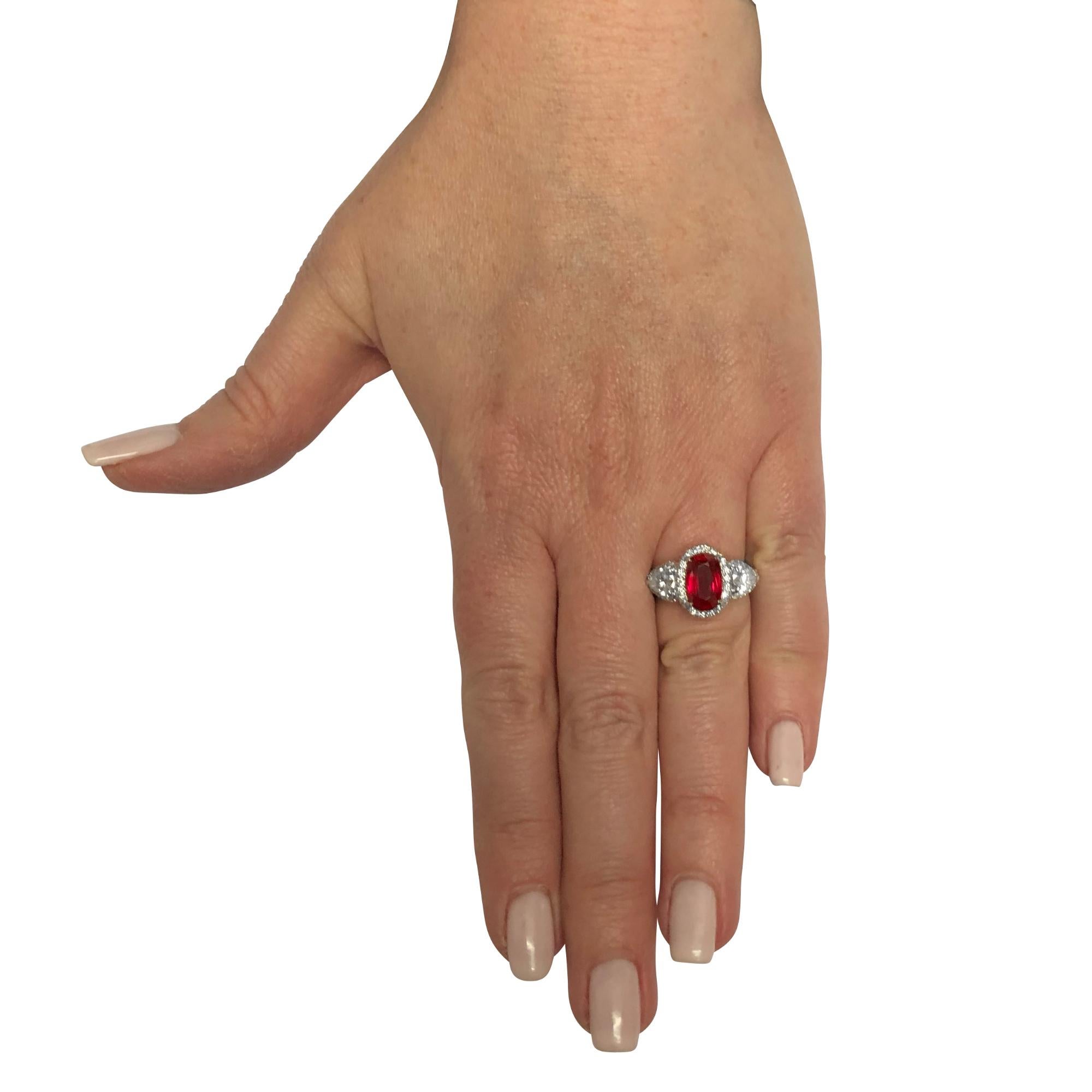Gorgeous ring crafted in platinum, showcasing a stunning AGL certified cushion cut unheated Burma ruby, weighing 2.42 carats, and two pear shape diamonds weighing 1 carat total, H color SI clarity framed with 50 round brilliant cut diamonds weighing