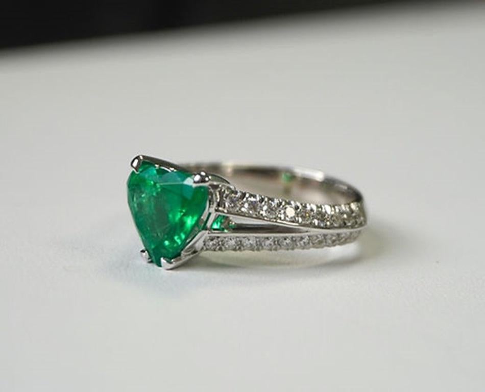 Emerald Weight: 2.42 CT, Measurements: 9.3 x 9.2 mm, Diamond Weight: 0.62 CT, Metal: 18K White Gold, Gold Weight: 6.73 gm, Ring Size: 6.5, Shape: Heart, Color: Vivid Green, Hardness: 7.5-8, Birthstone: May
