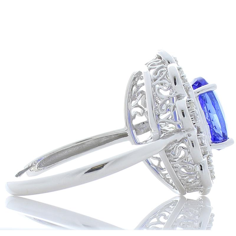A 2.42 carat vivid violet oval tanzanite suspended among petals is the perfect way to describe this ring. Measuring 7.20 x 9.17 mm, this gem originates near the foothills of Mt. Kilimanjaro in Tanzania. Its clarity & transparency are excellent, but